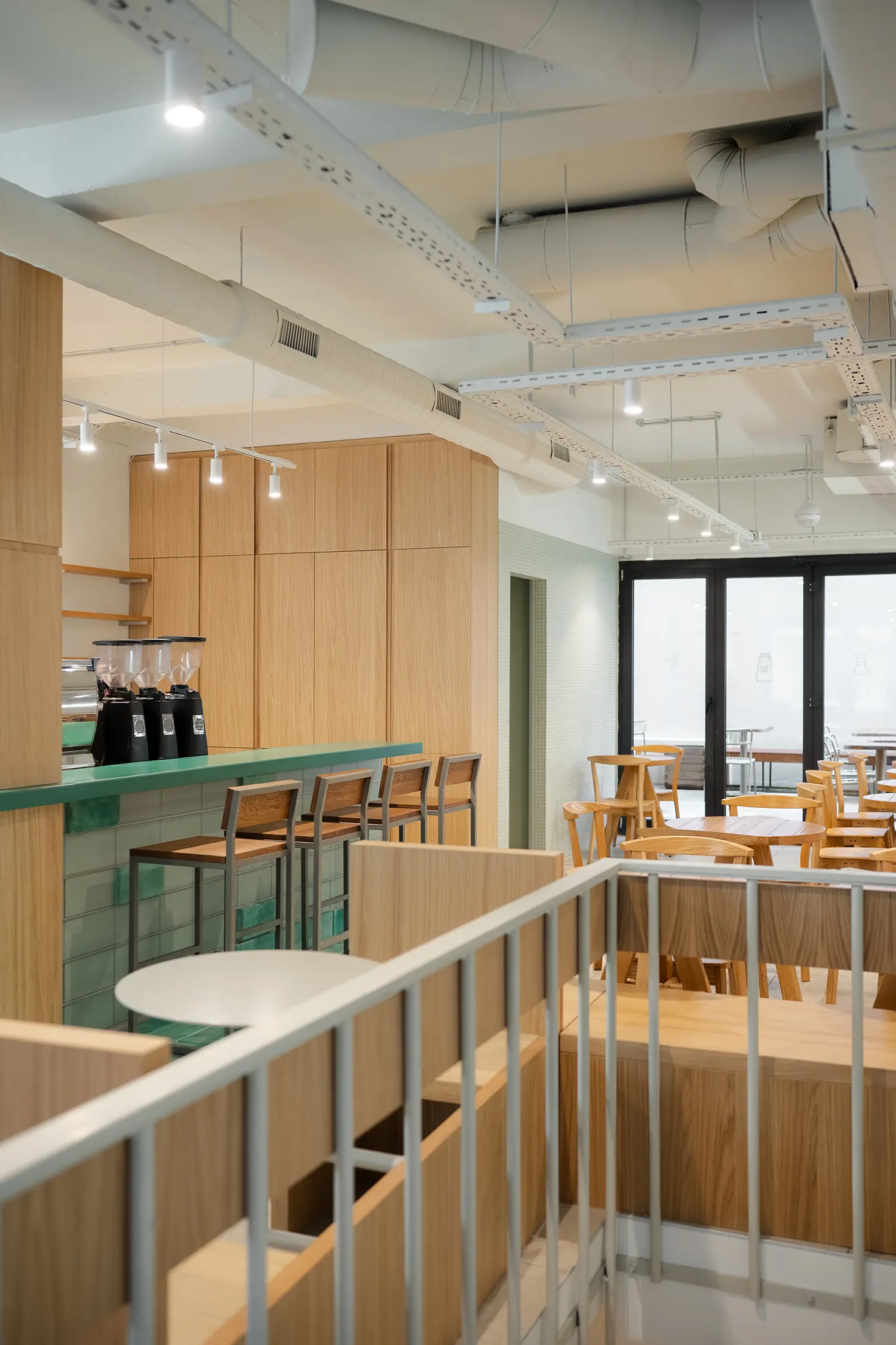 View from a staircase overlooking a contemporary space planning layout with a green bar.