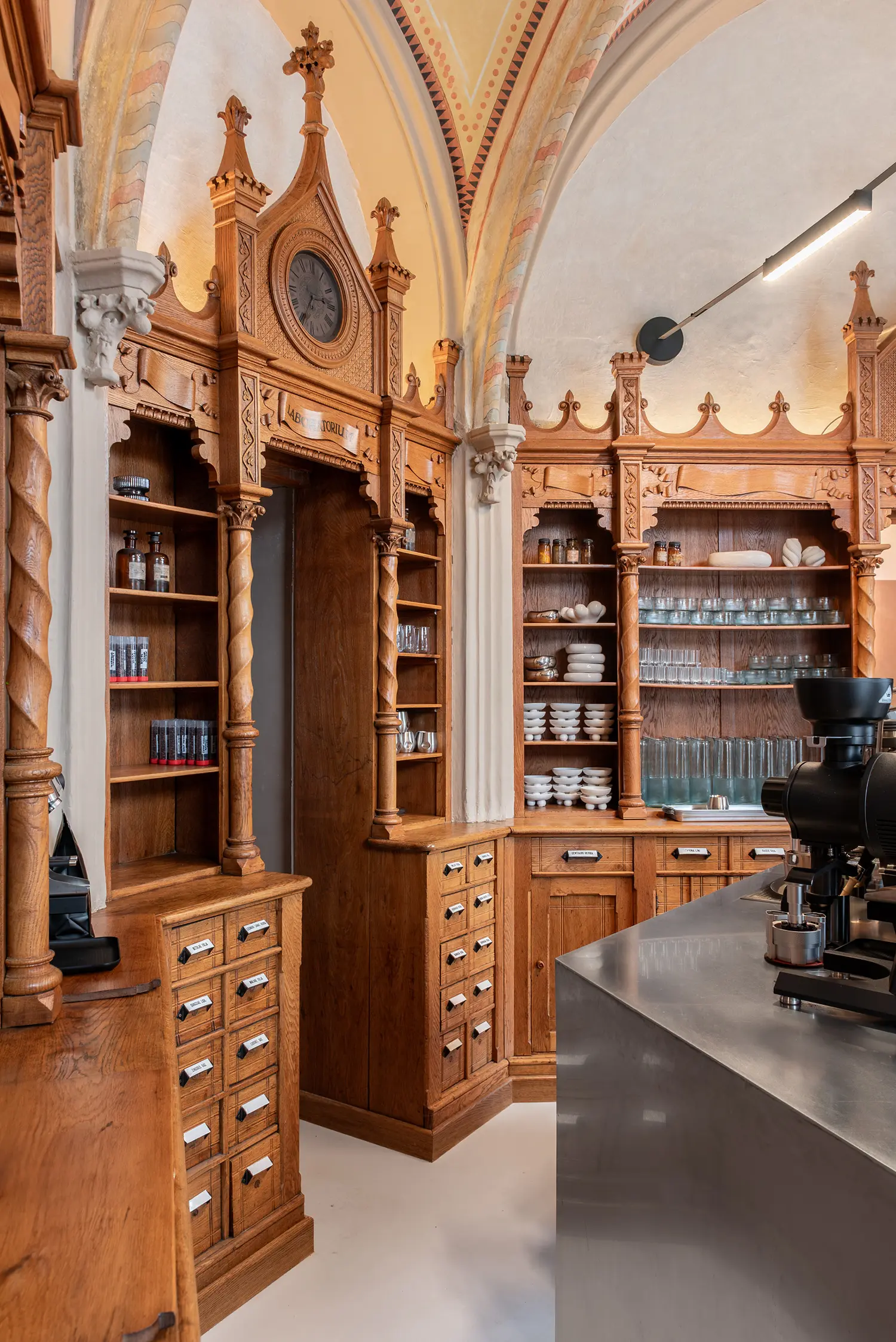 Close-up of twisted wooden columns and Gothic cabinetry with an integrated clock at Laboratorium.