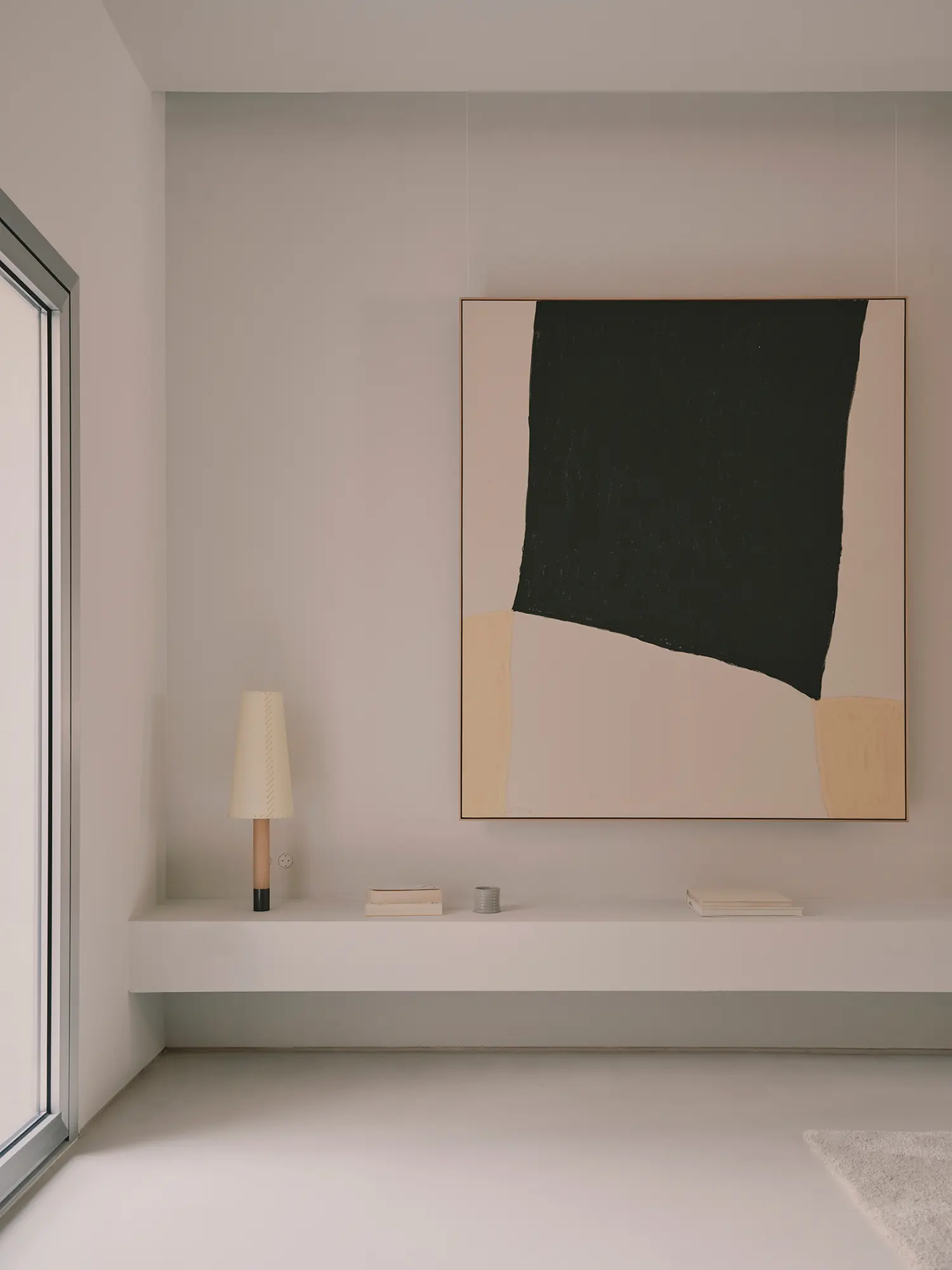 Large abstract painting in black and beige hanging above a white built-in shelf.