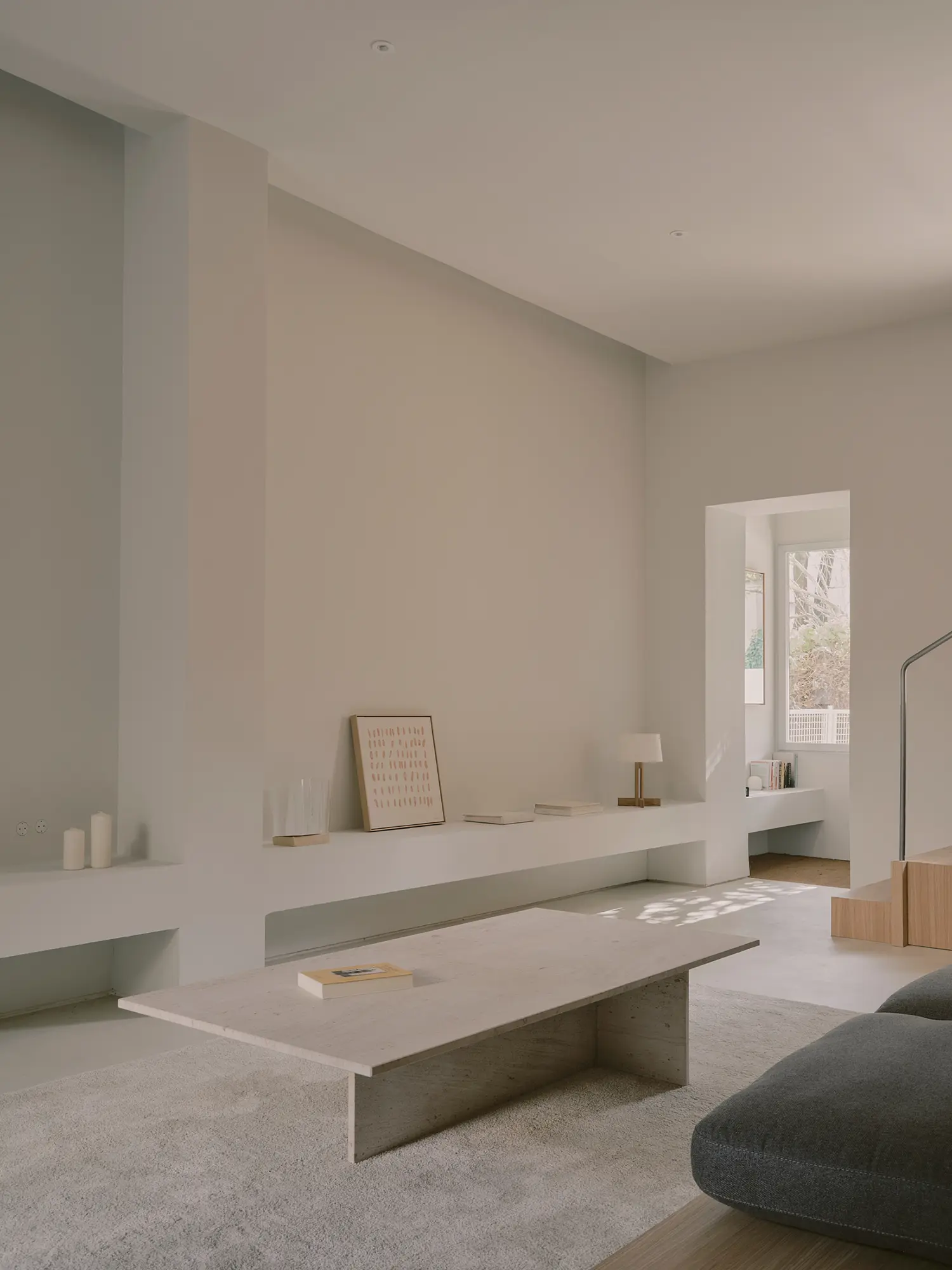 Bright living space with built-in white shelving and a stone coffee table.
