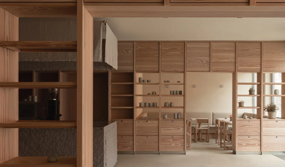Norm Architects Dan Bakstudio Varberg, Douglas fir shelving system, rough granite island, concrete floor, seating niche beyond