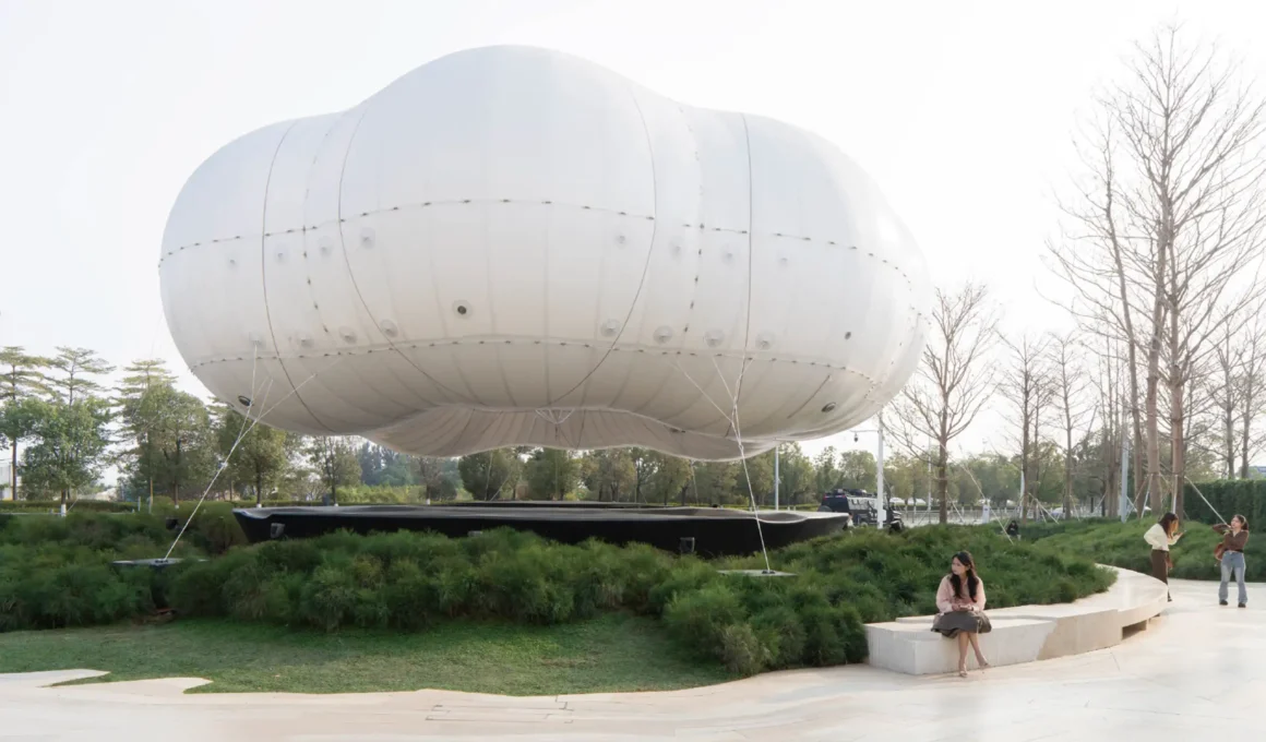 PILLS Studio air membrane cloud installation at MIXC VILLAGE Dongguan, white inflatable structure at low altitude, tethering cables, landscaped plinth