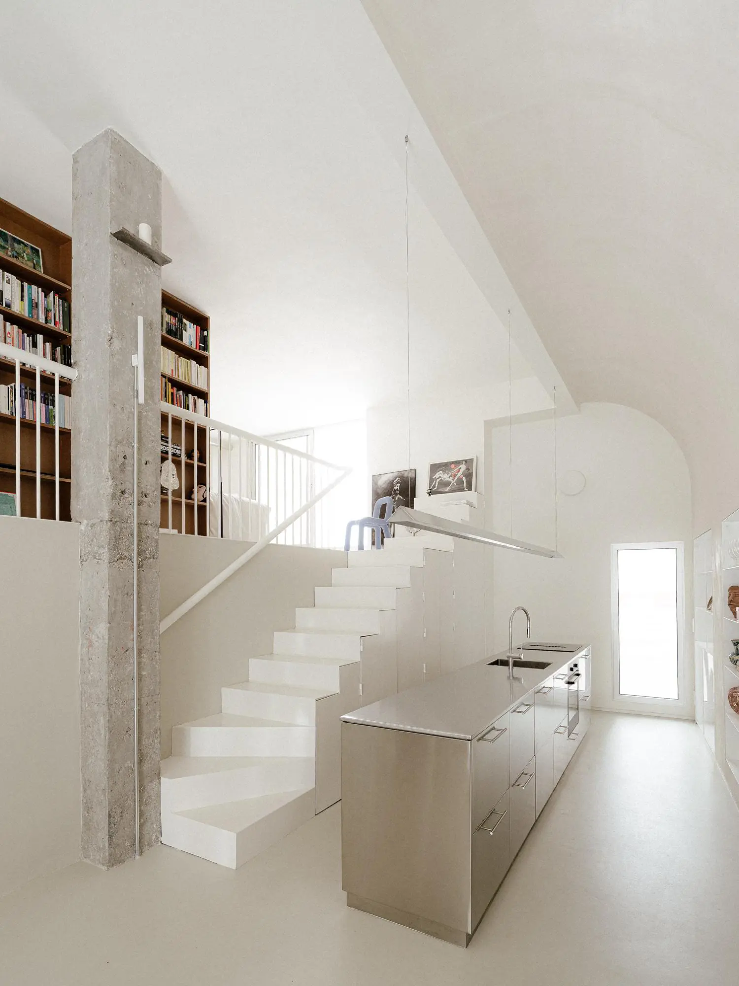 Industrial concrete pillar and steel kitchen island in a loft conversion by Burr Studio.