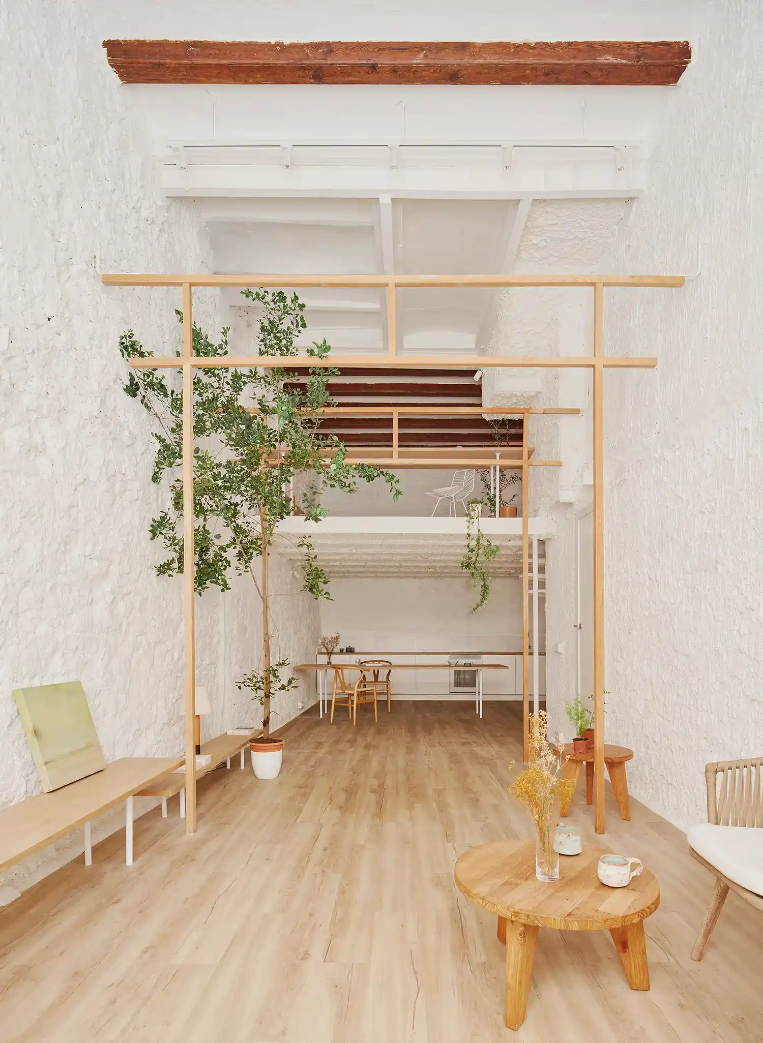 Double-height loft apartment in Barcelona with structural timber Torii frames.