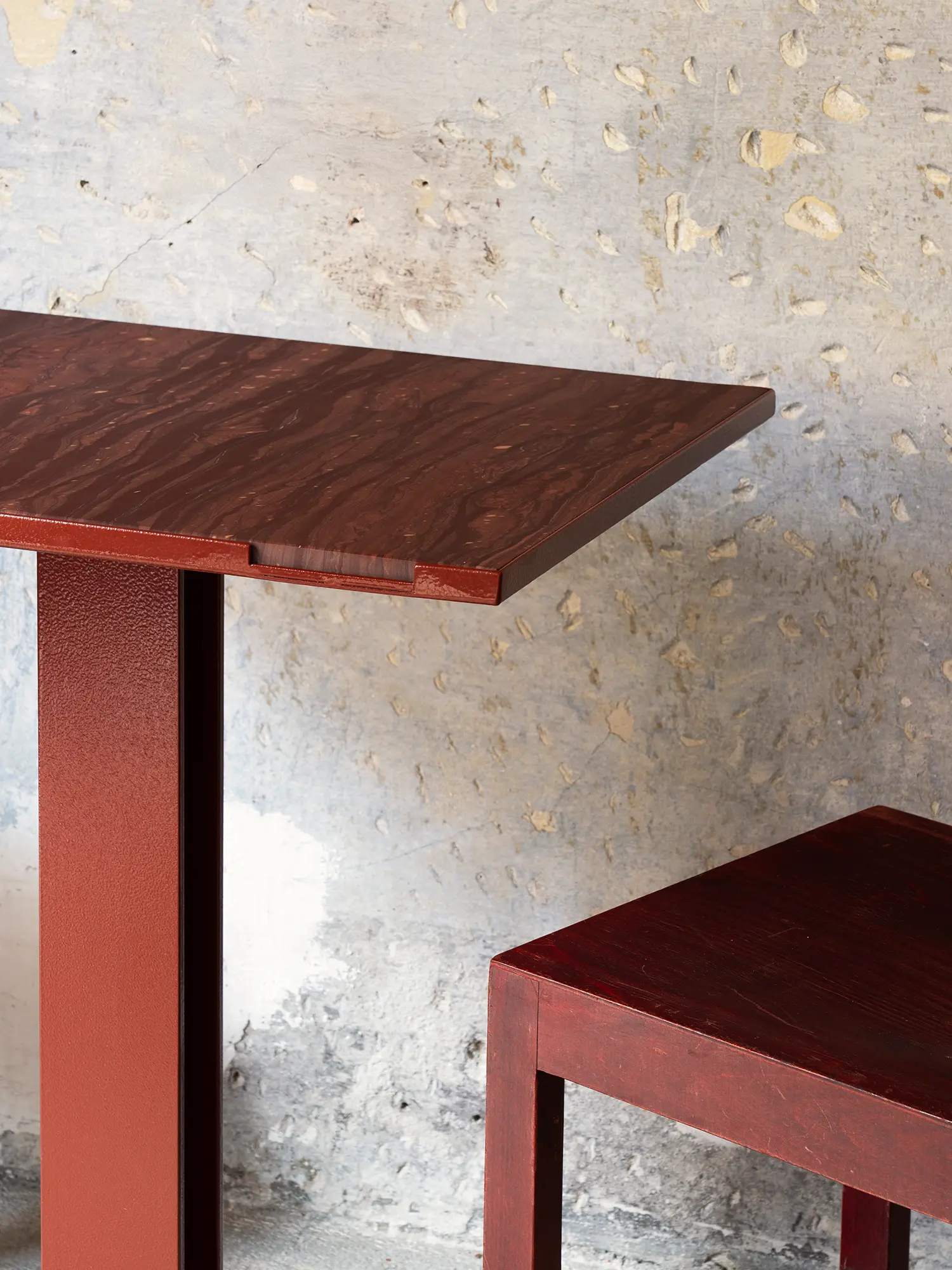 Macro shot of a Wenghe Bordeaux marble tabletop showing deep wood-like grain and a red iron base.