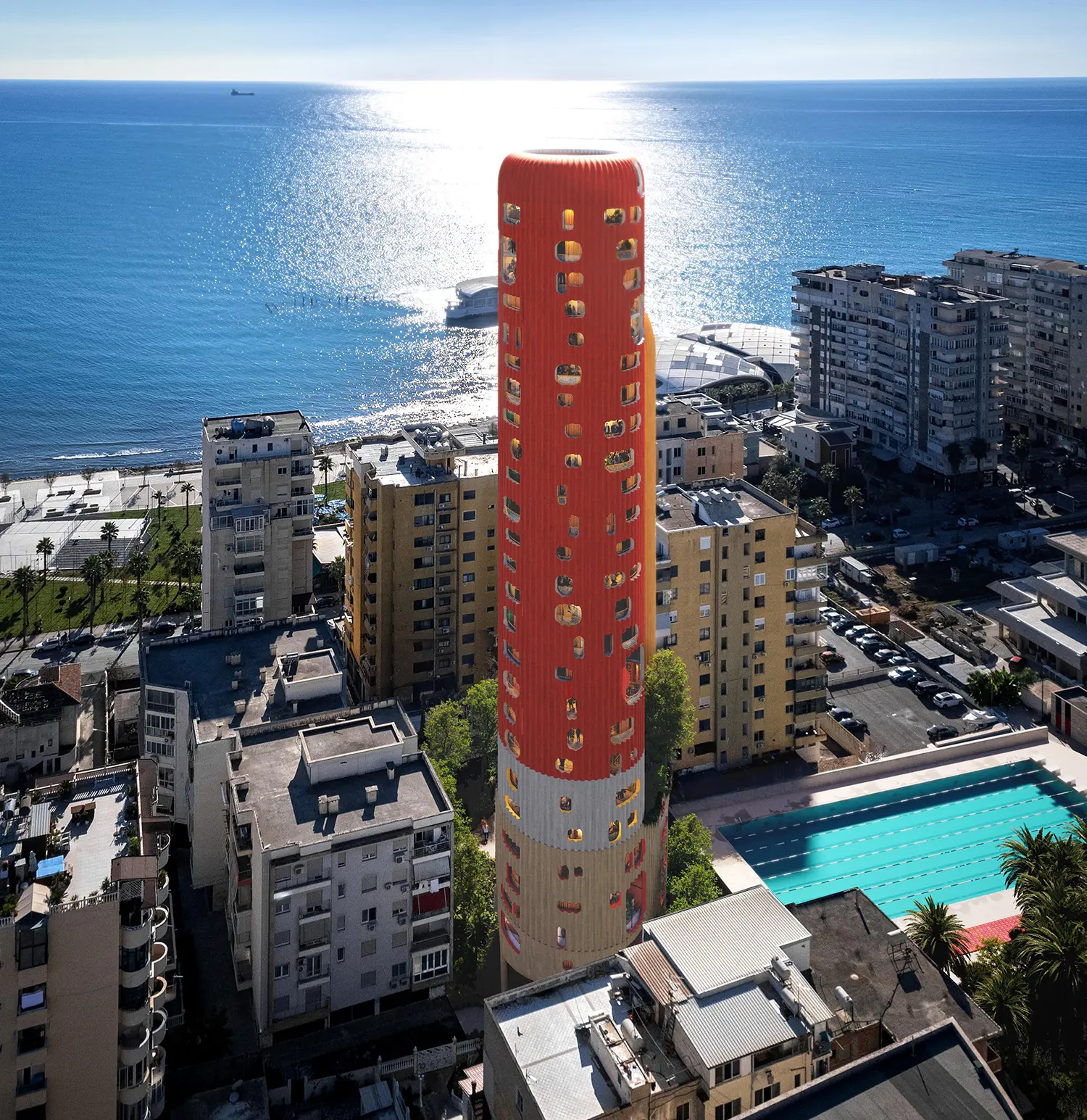 High-angle aerial shot of the red Sky-K tower showing its circular footprint and proximity to the sea.