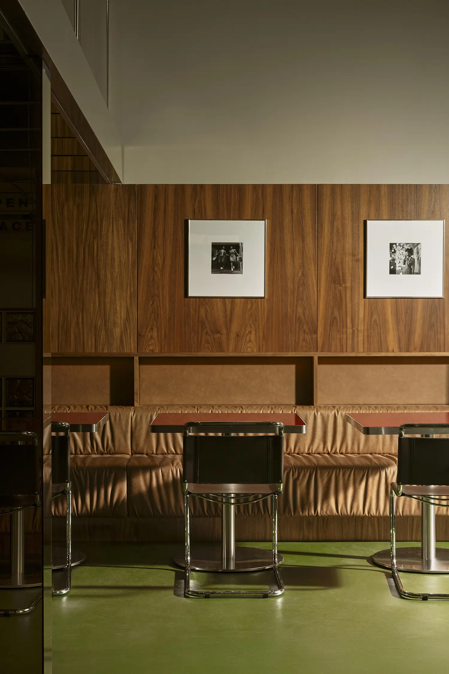 A symmetrical view of leather banquette seating against walnut wood paneling in Lève Office Bar.