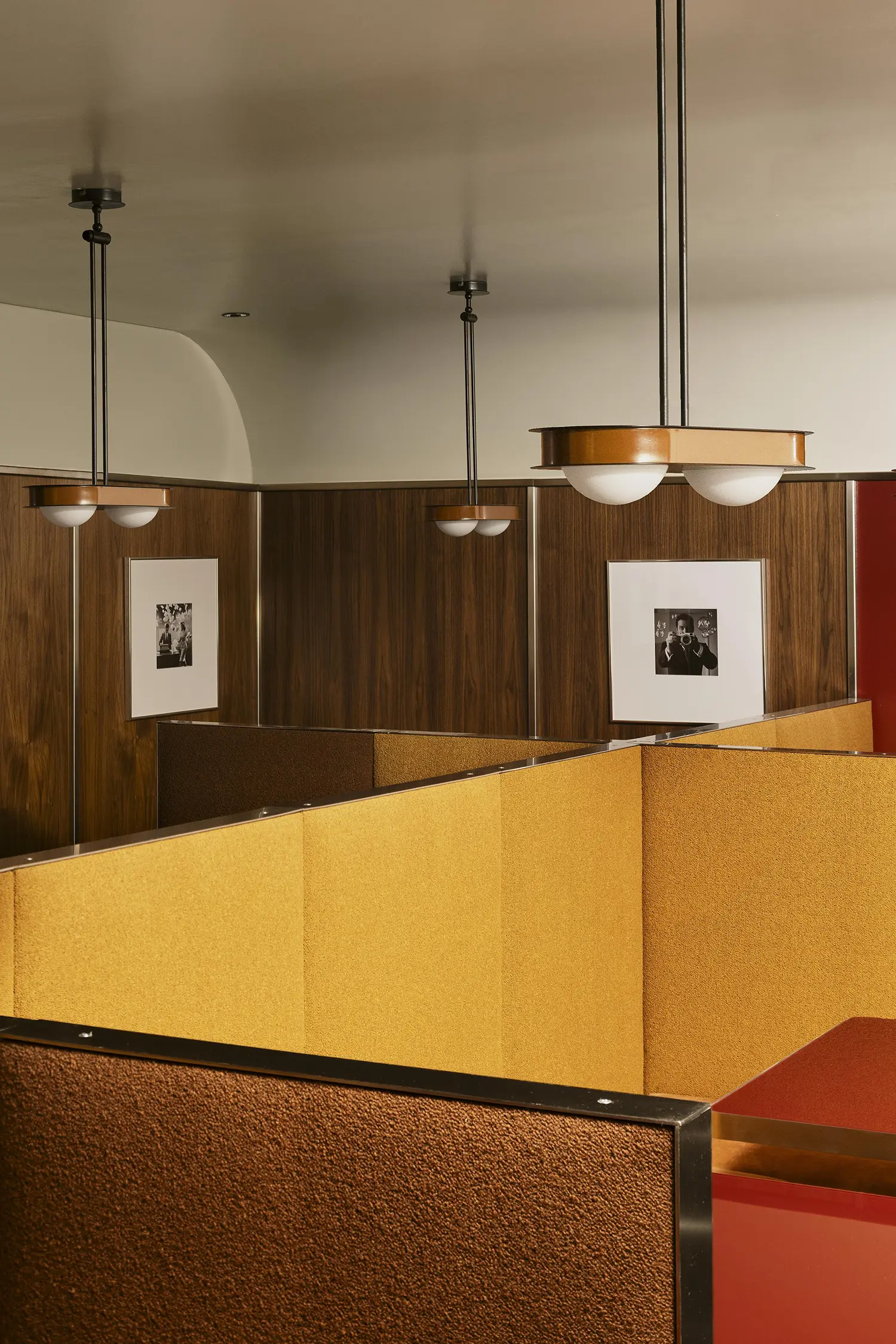 Close-up of geometric textured fabric office-style partitions and custom metal-trimmed light fixtures.