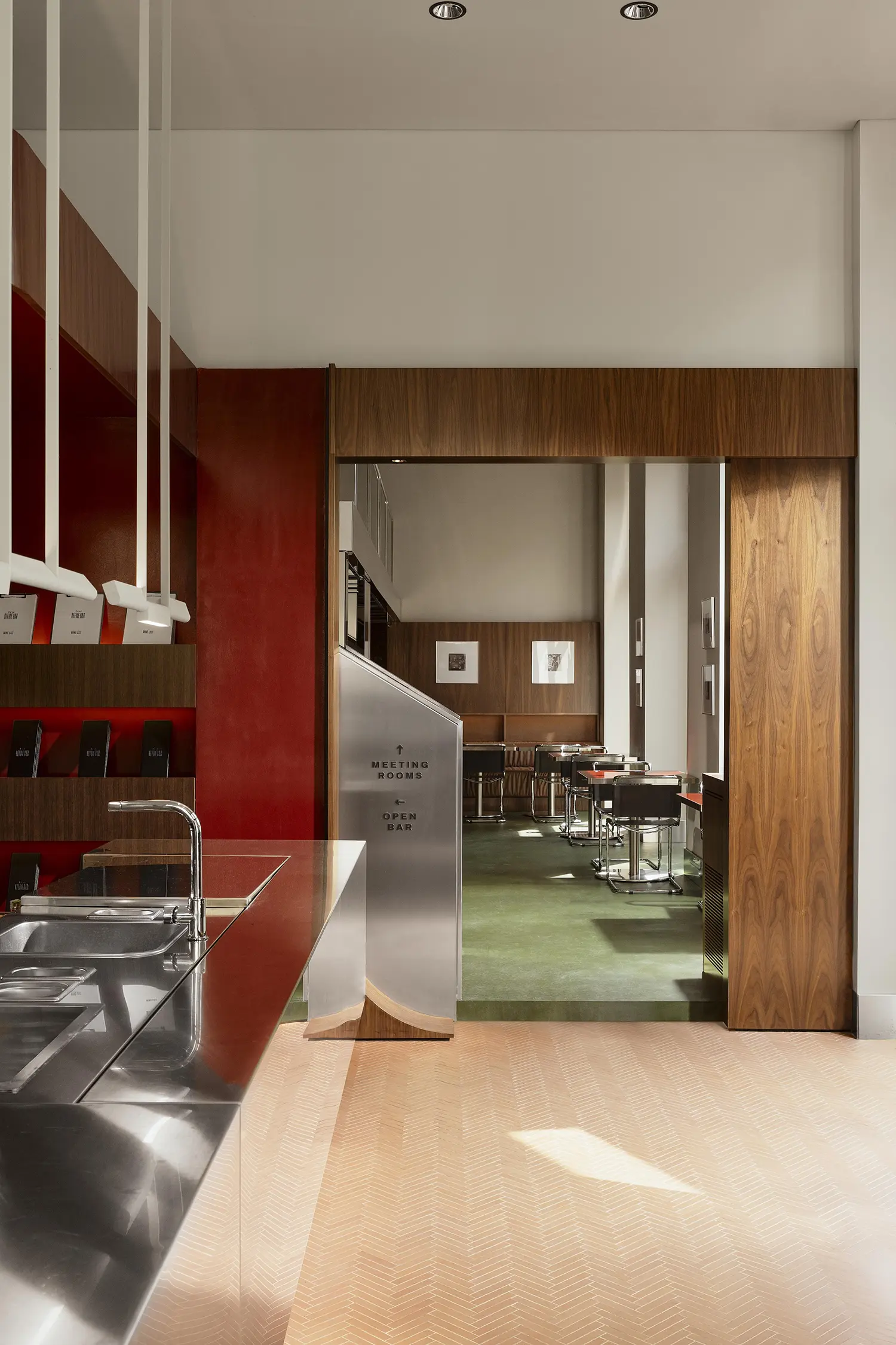 An architectural view from the stainless steel counter looking toward the green-floored dining room.