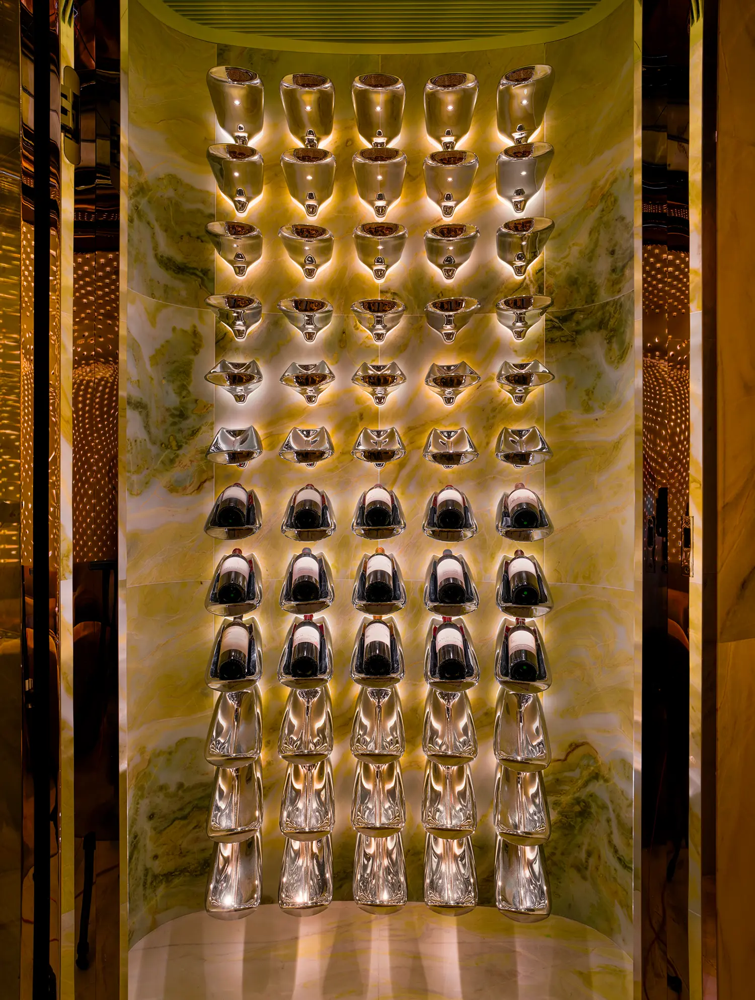 Bespoke stainless steel and green marble bottle display in the private room of Peridot bar.