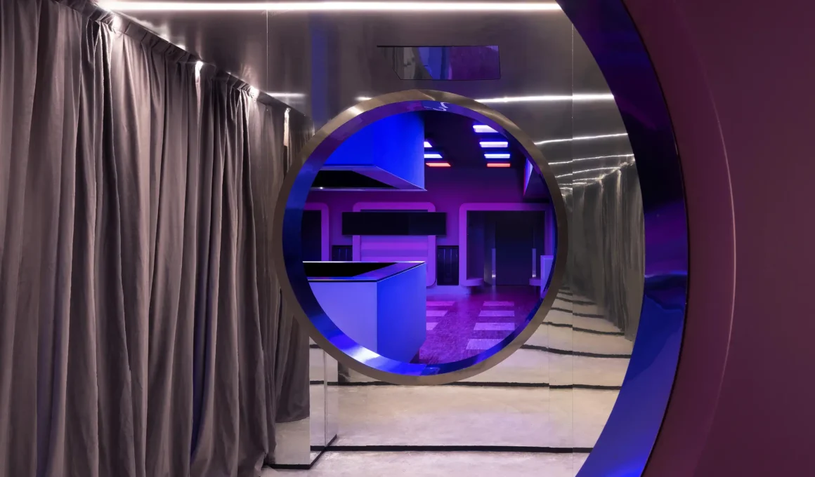 DURO club Milan by Velvet Studio, circular porthole framing bar area with blue LED lighting, mirrored corridor