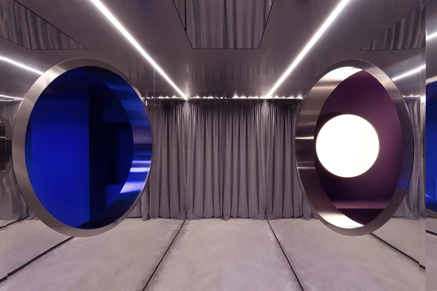 DURO club Milan Velvet Studio, two circular steel portholes with blue and purple LED light, mirrored ceiling, velvet curtain