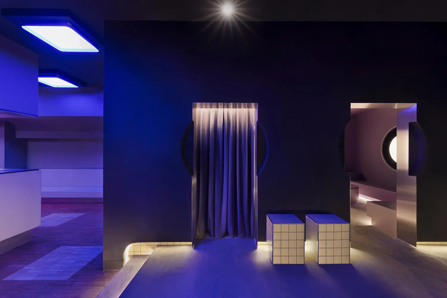 DURO club Milan Velvet Studio, blue lit corridor with velvet curtain, tiled cube seats, circular porthole and steel frame