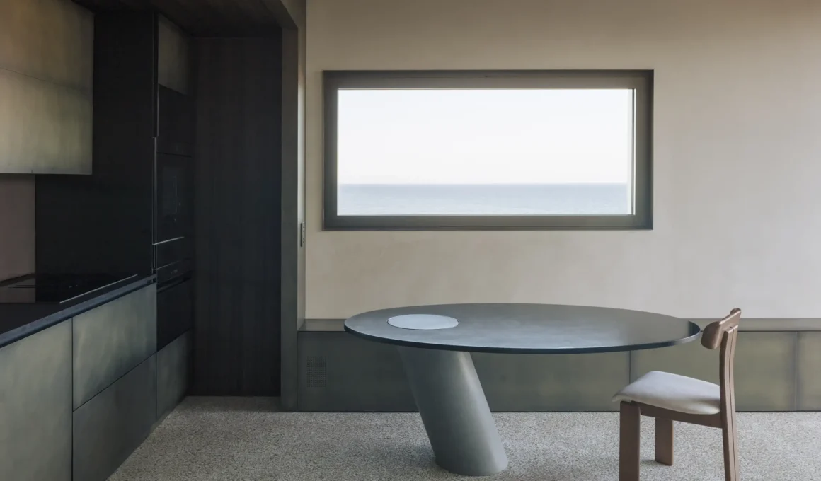 Villa S-2113 Calvi Ceschia Viganò, dining area with round burnished metal table, Genoese terrazzo floor, horizontal sea-view window