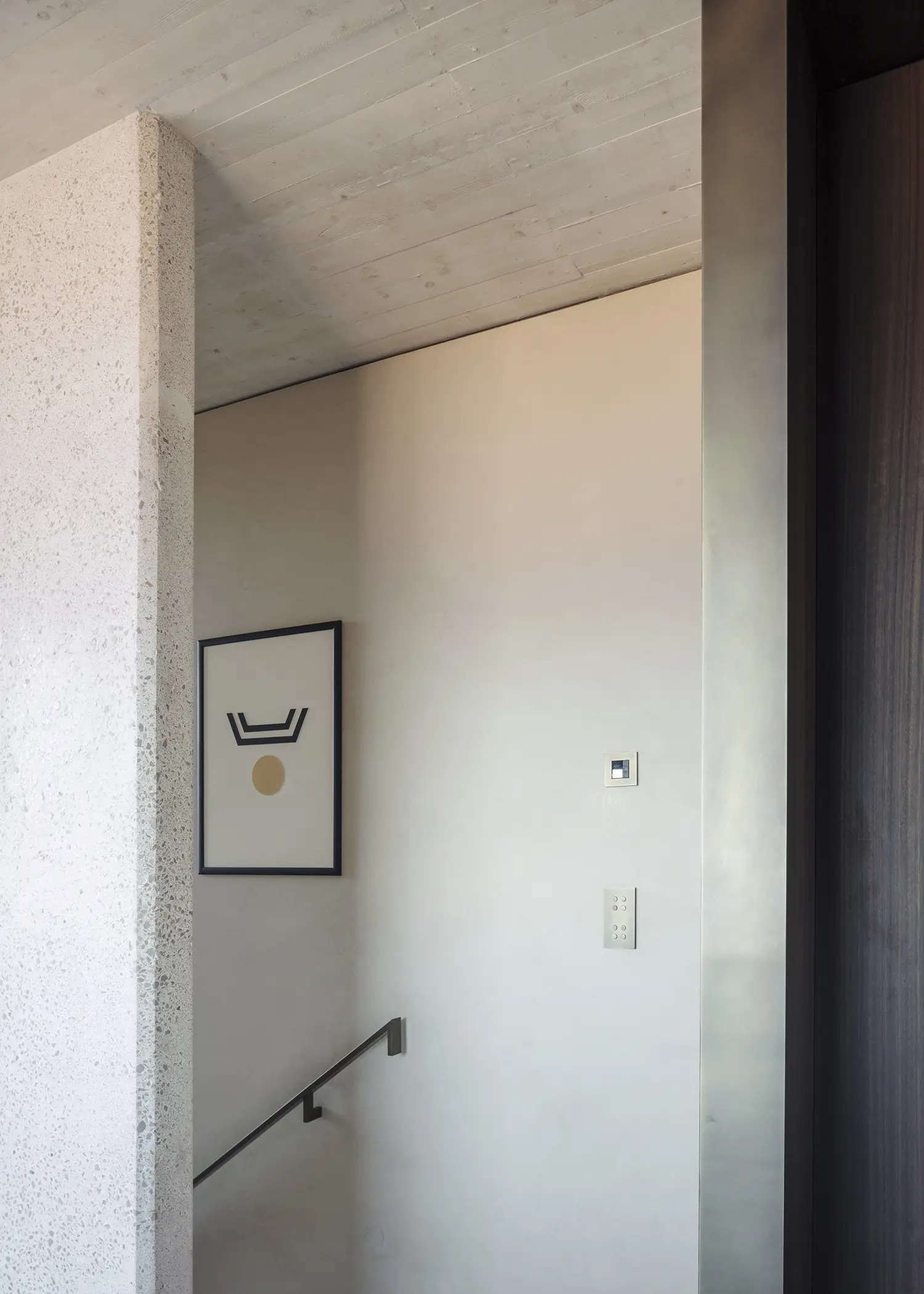 Villa S-2113 Calvi Ceschia Viganò, staircase with bush-hammered concrete wall, dark timber door, minimal steel handrail