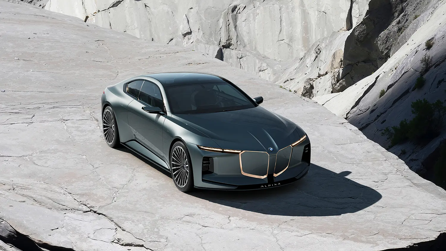 High-angle front quarter view of the Vision BMW ALPINA concept car parked on a light grey rocky platform.