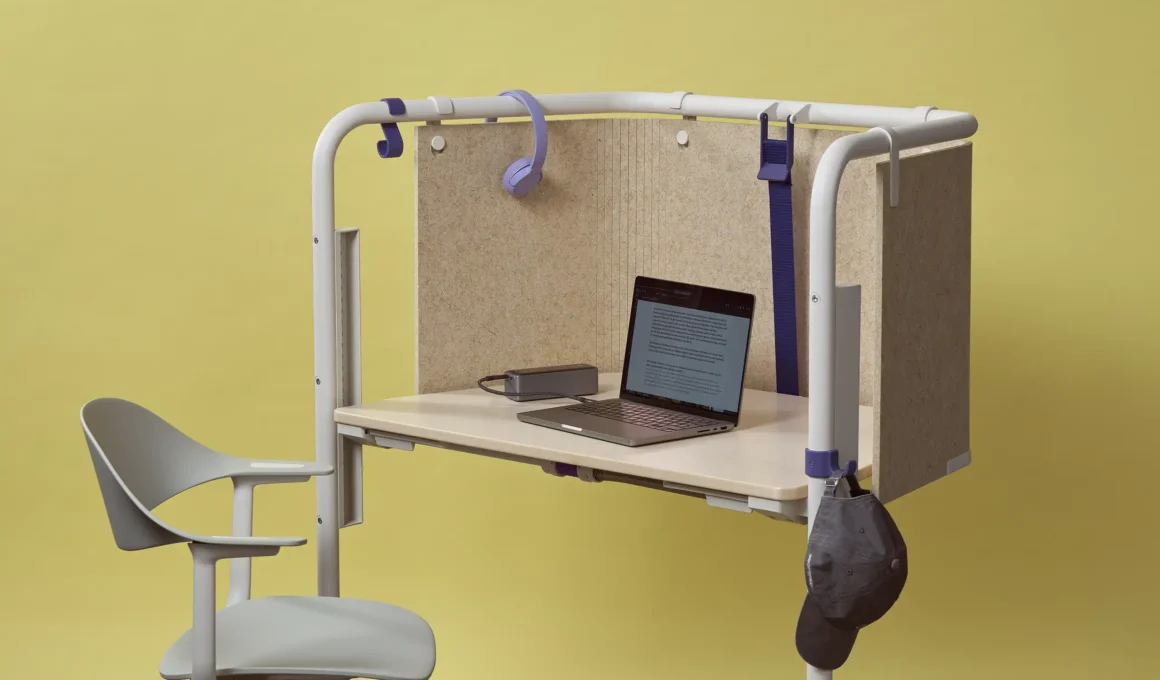 A mobile Vitra Scout desk with a light wood top, white tubular frame, and beige privacy panels.