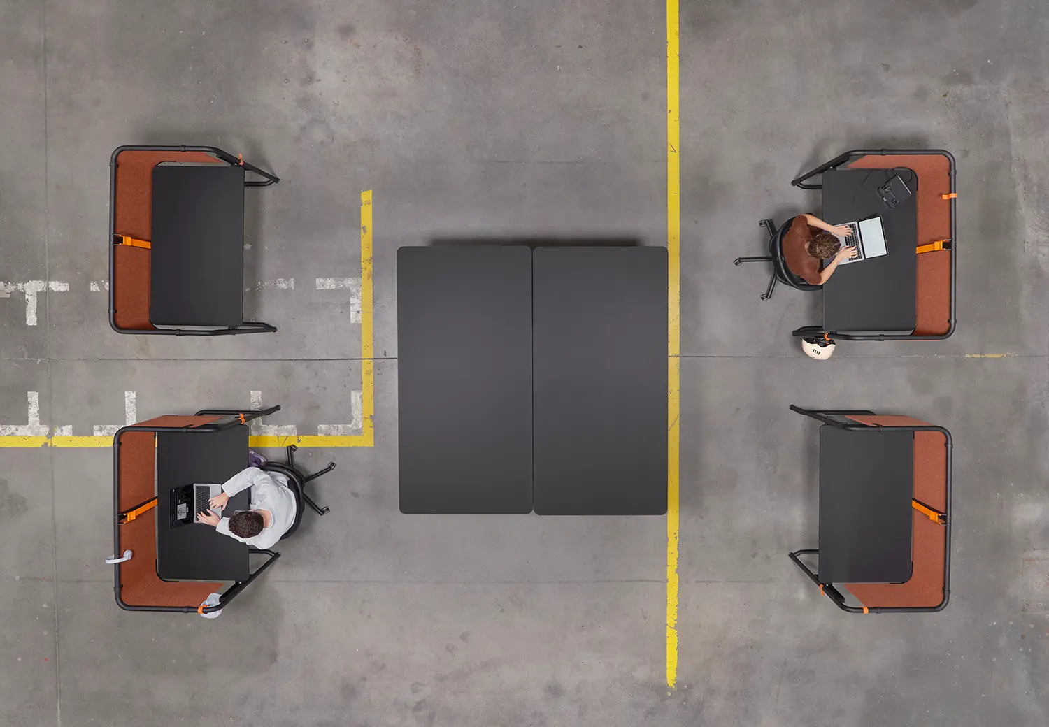 Overhead view of four Scout desks arranged in a workspace with industrial concrete flooring.