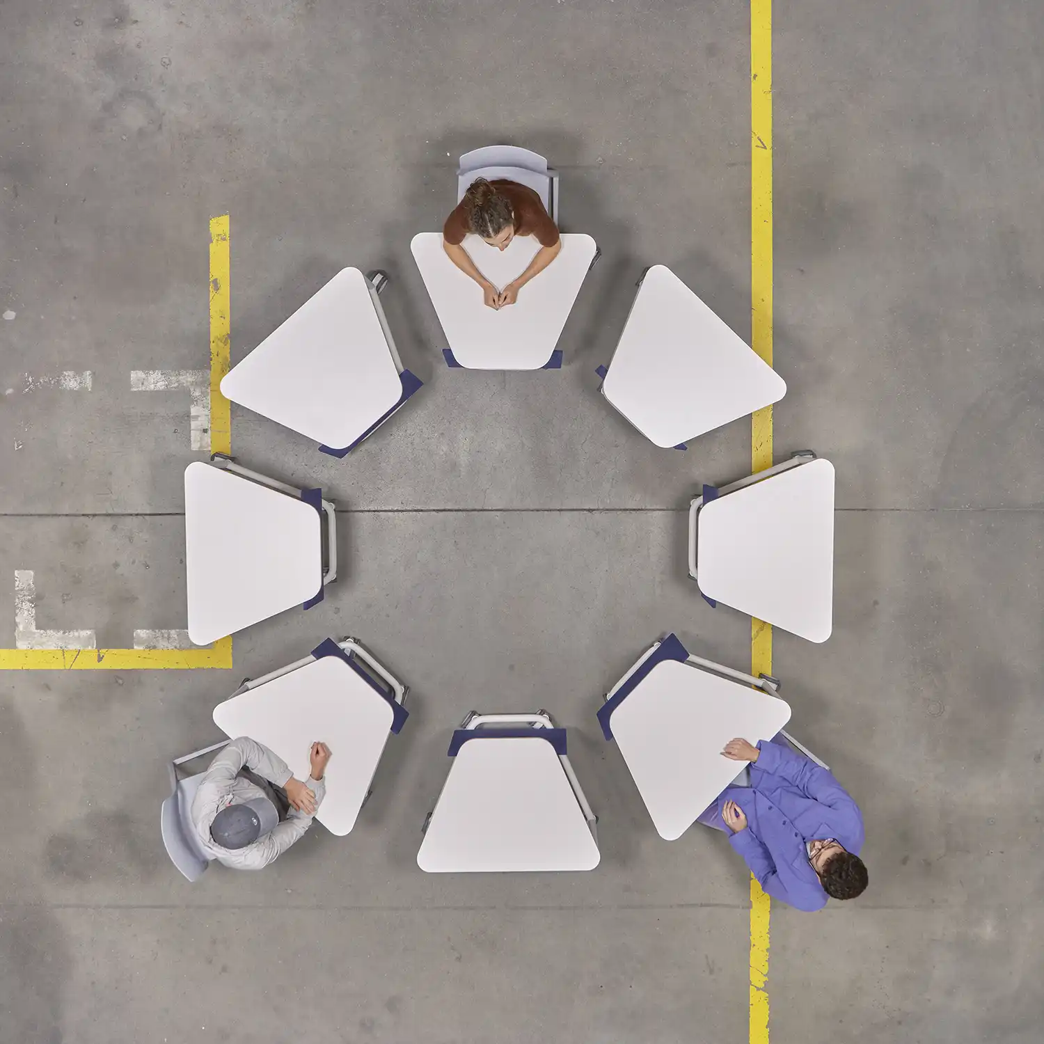 Bird's-eye view of eight white trapezoidal Scout tables arranged in a large circle.