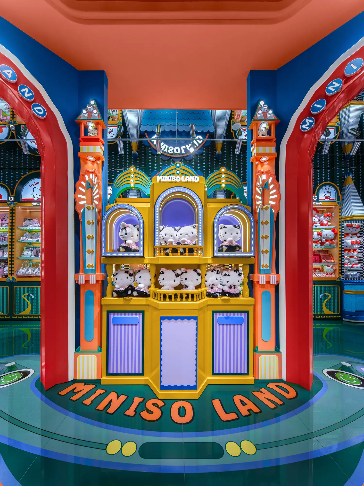 Centered shot of a yellow temple-like display unit flanked by red arches inside MINISO LAND Guangzhou.