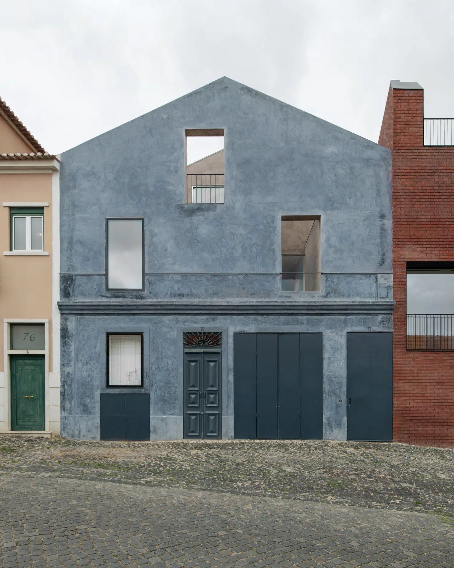 Blue House extrastudio Marvila Lisbon street facade ultramarine lime plaster cobblestone original 1893 door garage panels