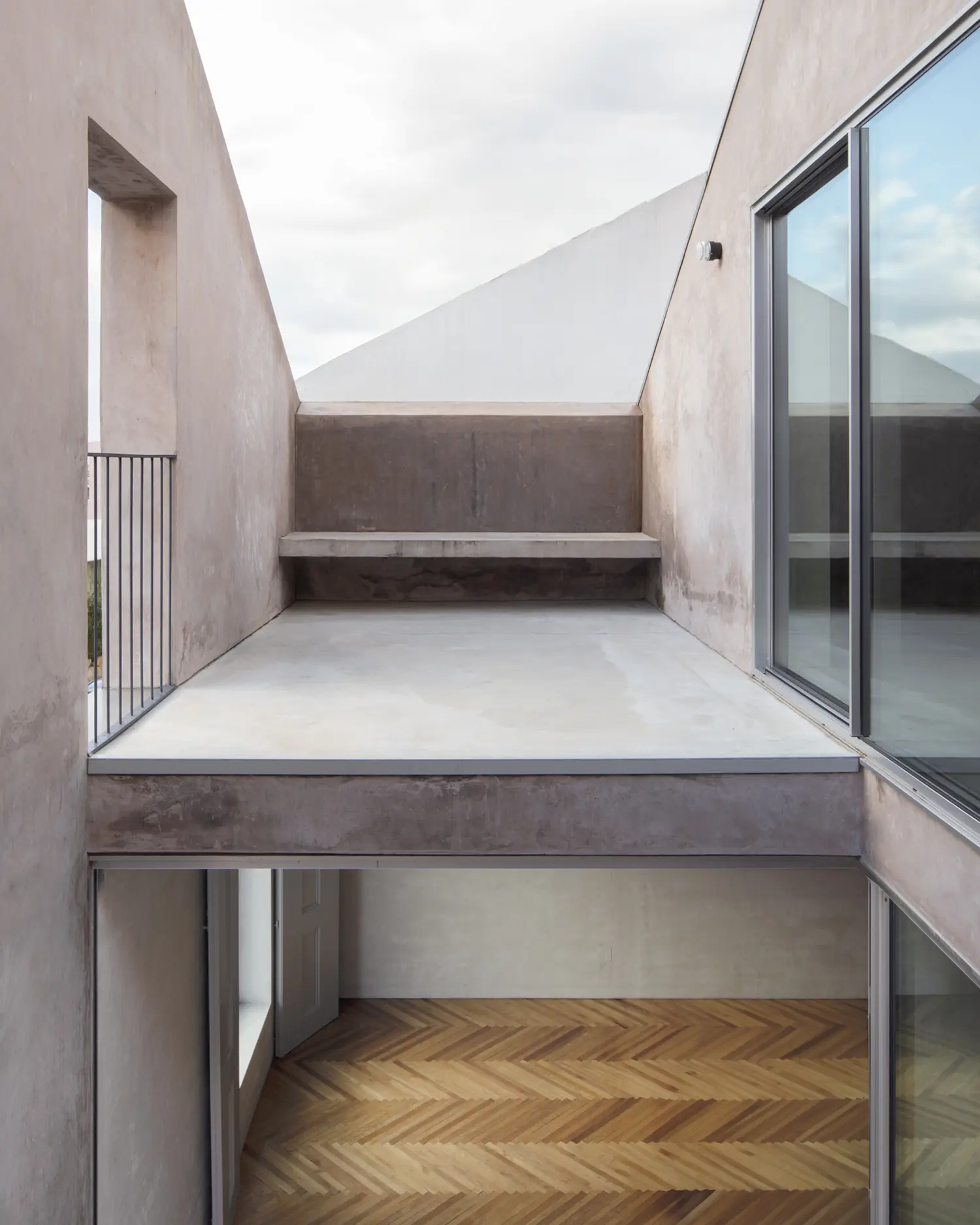 Blue House extrastudio Marvila Lisbon double height courtyard concrete steps herringbone parquet sky cut plaster walls
