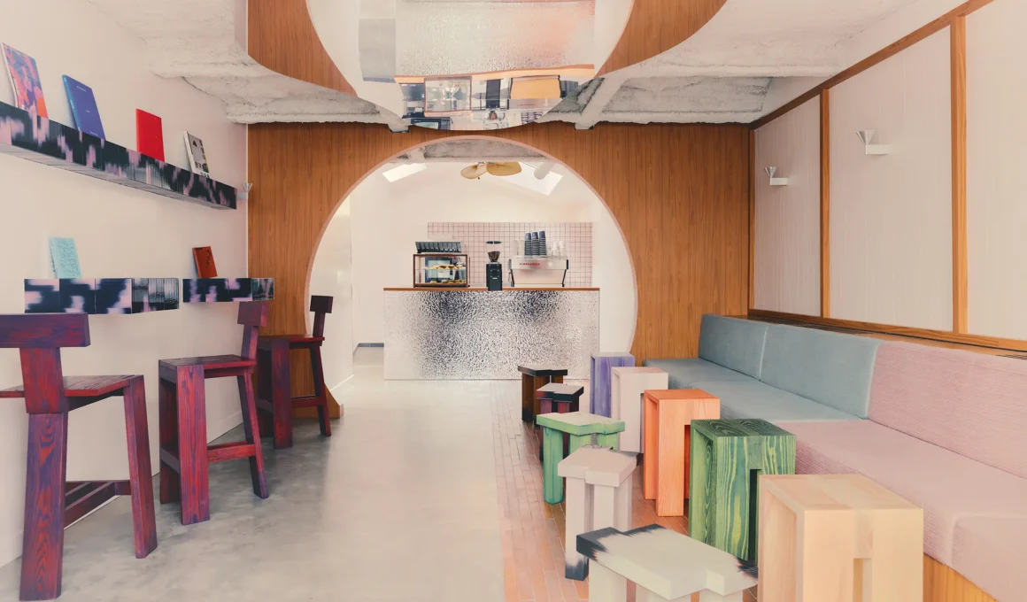 Café Shin Marais Uchronia Paris main room arch hammered chrome counter multicolor wood stools bench seating oak paneling