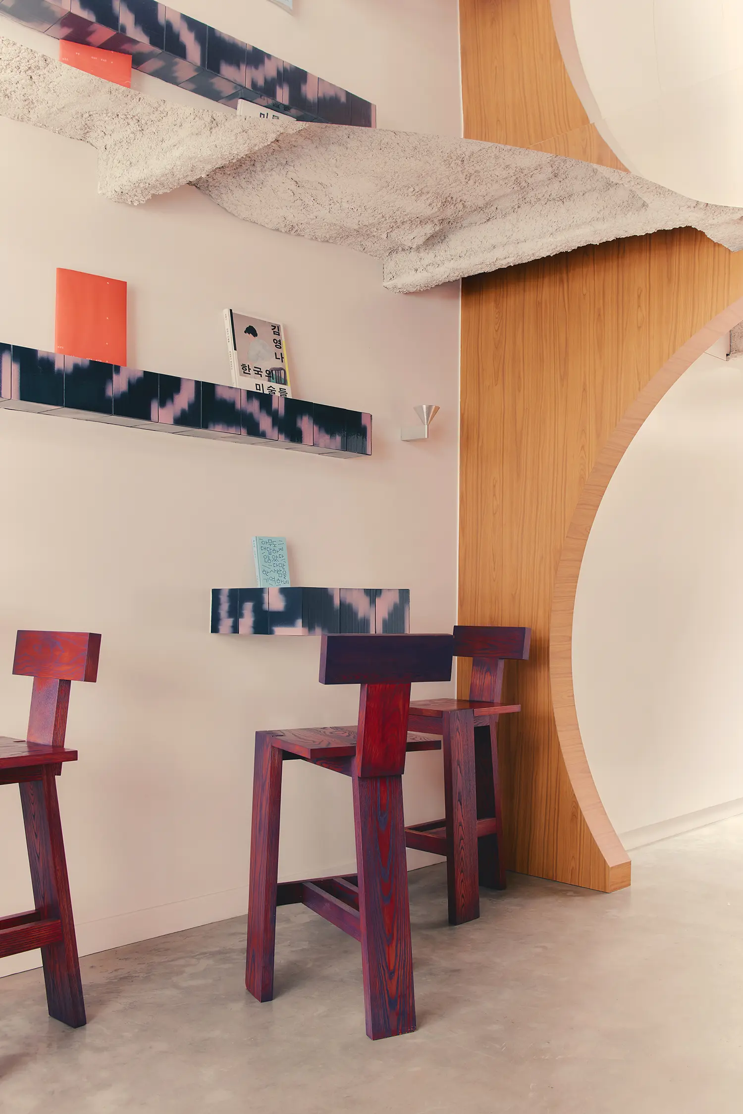 Café Shin Marais Uchronia Paris main room arch oak paneling ikat tile shelving stained wood chairs raw concrete beam
