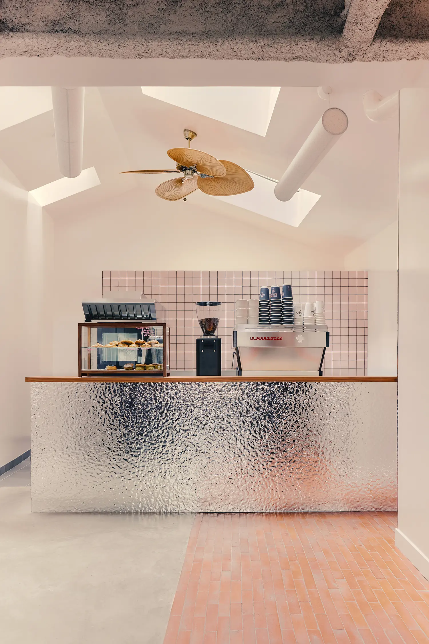 Café Shin Marais Uchronia Paris counter hammered chrome panels pink ceramic tile splashback skylights rattan ceiling fan