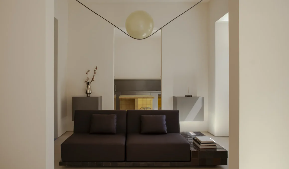Casa Aether AB+AC Architects Lisbon living room Moon fiberglass pendant dark sofa yellow kitchen background 115sqm