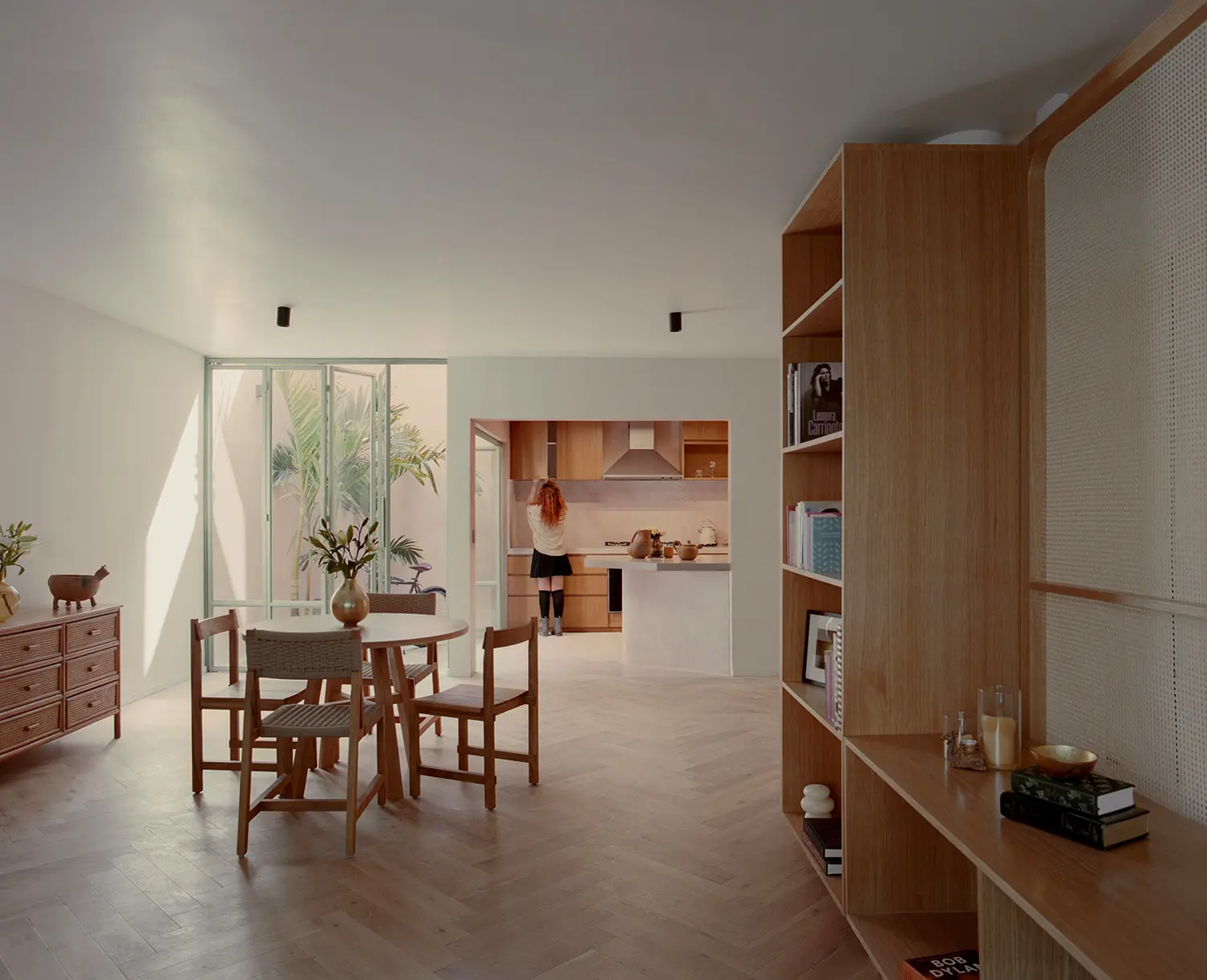 Casa Xoltic AMASA Estudio, open plan dining room and kitchen with herringbone parquet, wood millwork shelving, patio connection, Coyoacán