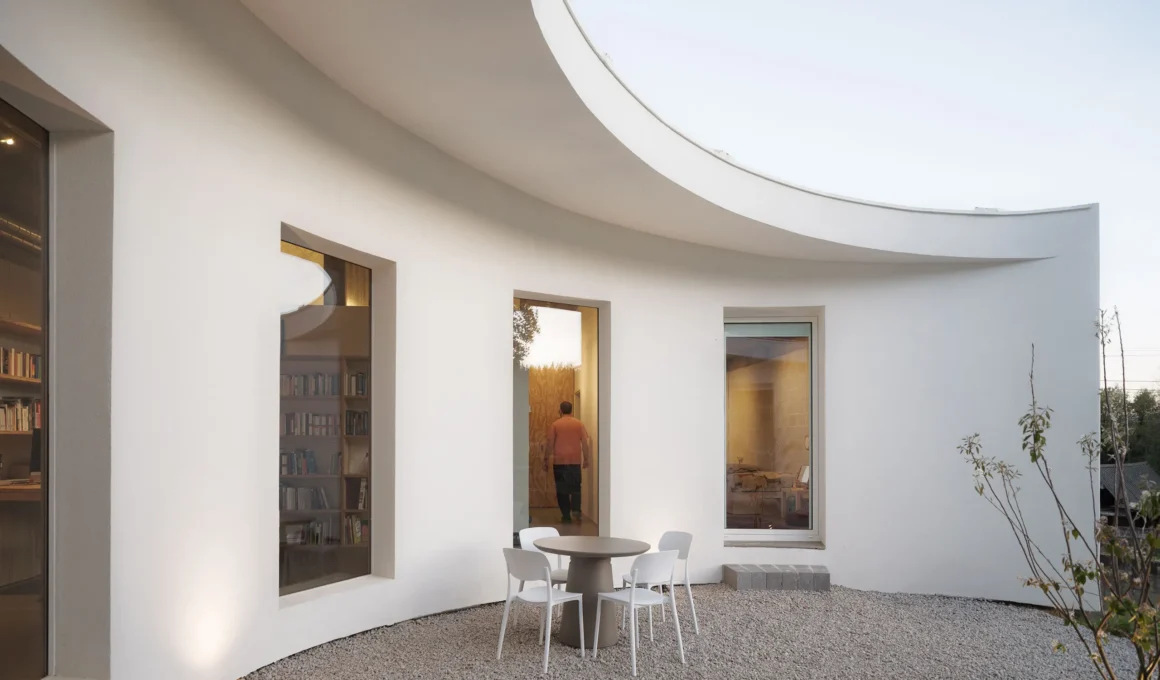 Cecebre House Sinaldaba Galicia courtyard rendered masonry curved wall evening figure threshold