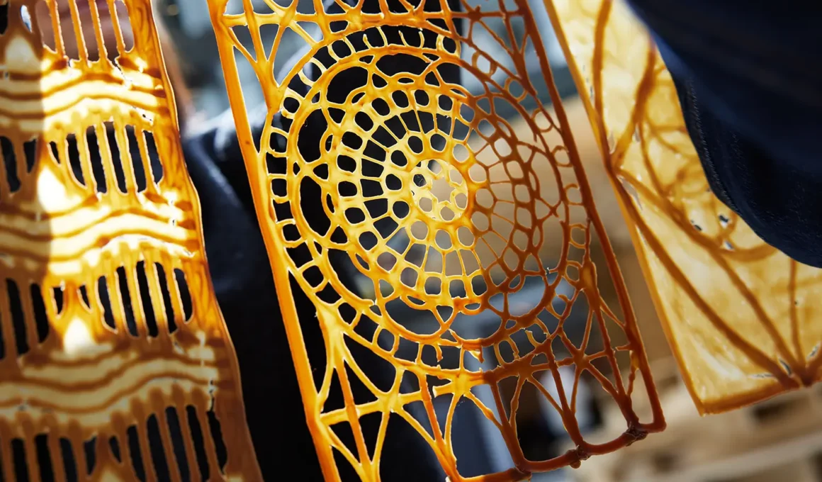 3D printed yeast-based architectural panel, circular spiral lattice pattern, amber orange hue, Chalmers University of Technology research
