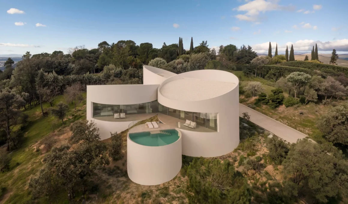 House in Las Rozas by Fran Silvestre Arquitectos, aerial view of five cylindrical volumes on hillside with pool