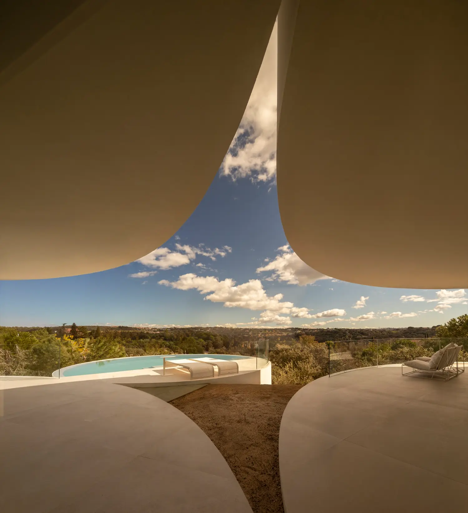 Detail view of House in Las Rozas, oblique roof cuts of two cylindrical volumes framing sky and pool terrace below