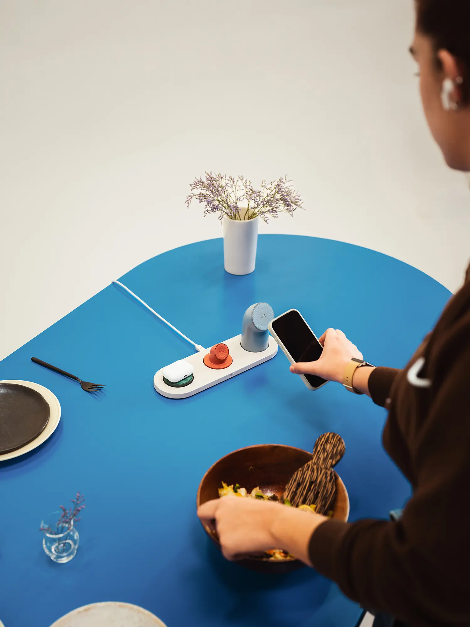 LAYER Daily Objects Node wireless charging dining table lifestyle mano telefono blue surface
