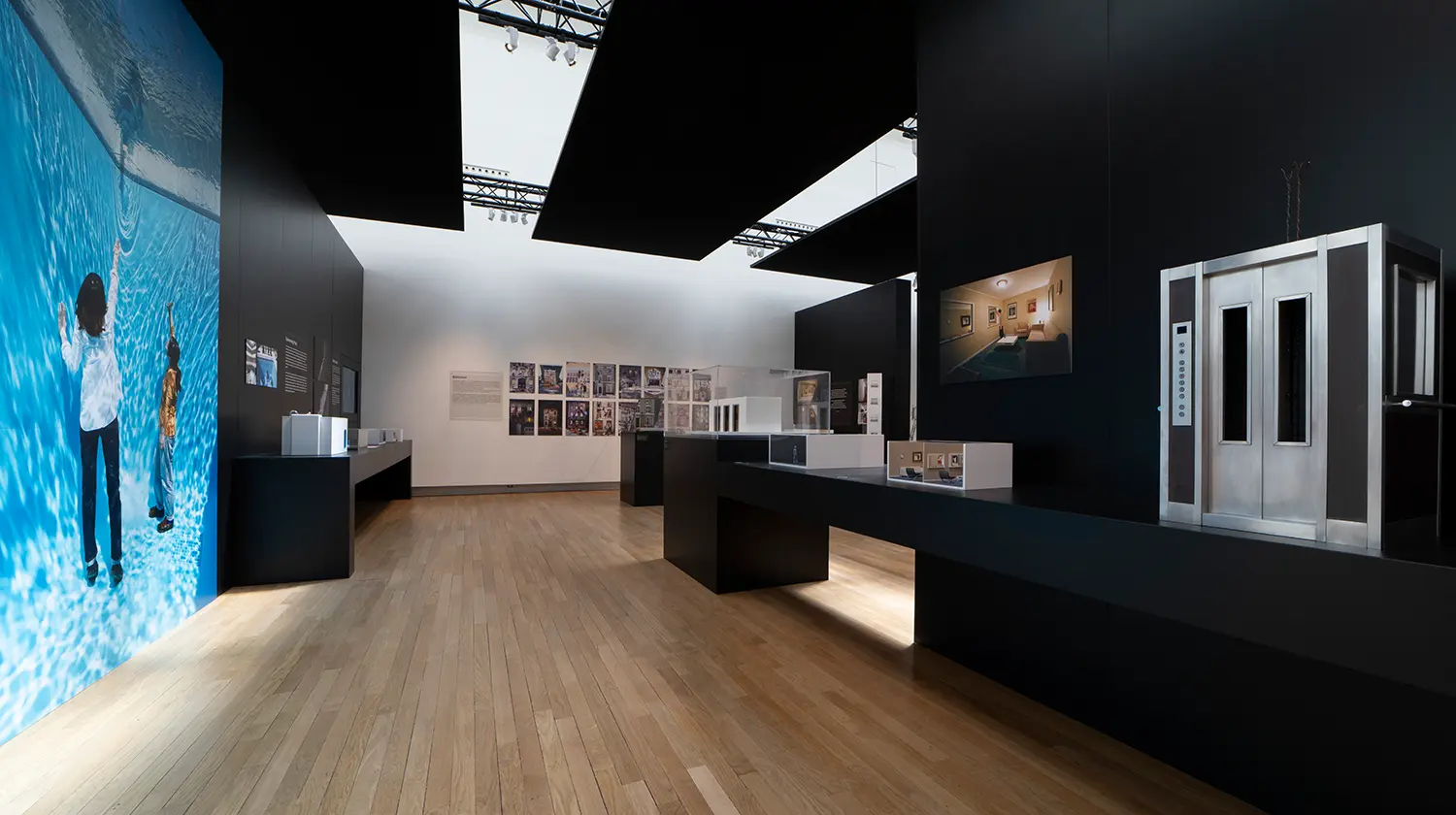 Leandro Erlich The View Grand Palais Paris, two illuminated apartment window videos with Venetian blinds, viewer silhouette, dark gallery wall