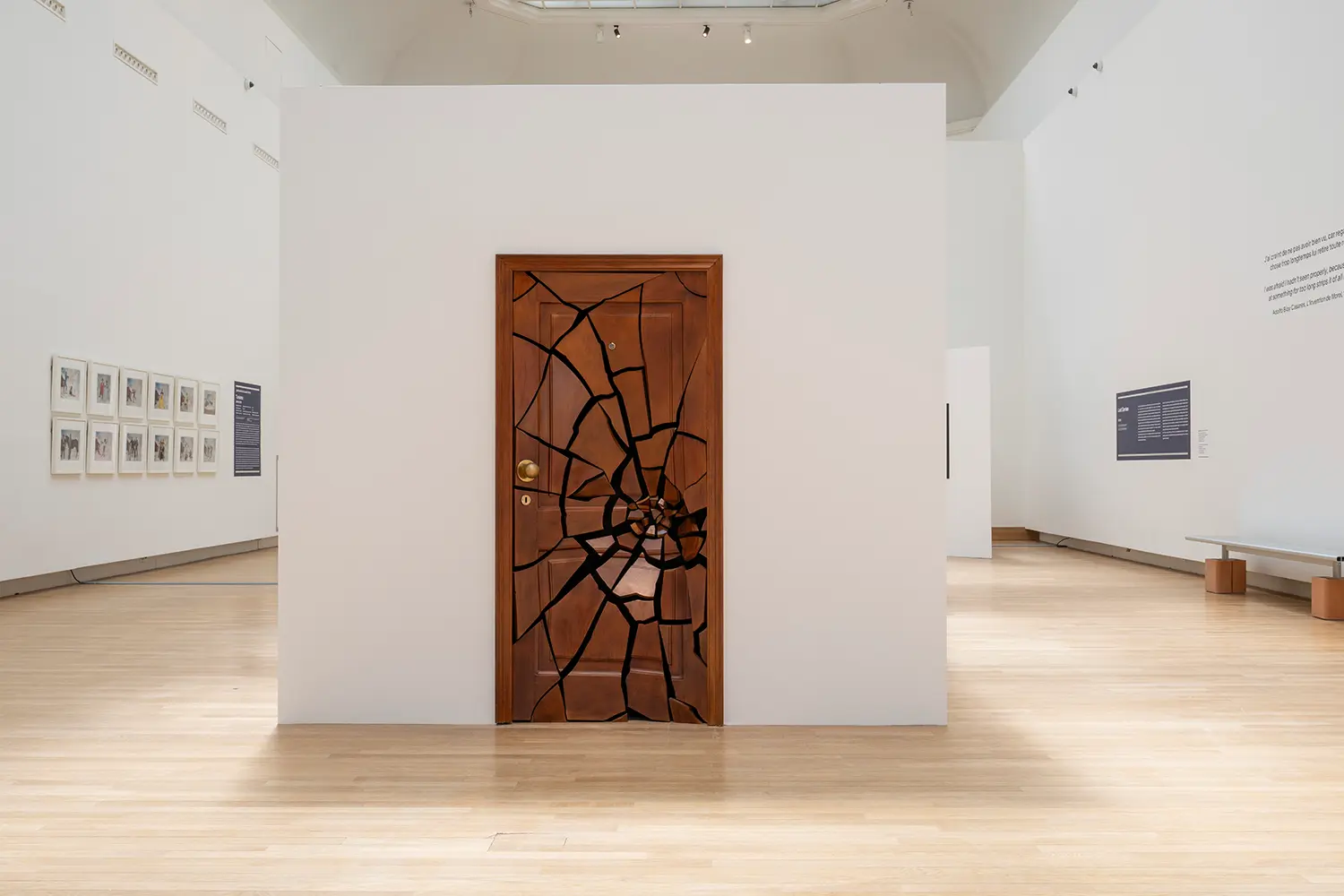 Leandro Erlich installation Grand Palais Paris, full-size wood residential door with spider-web crack pattern on white partition wall