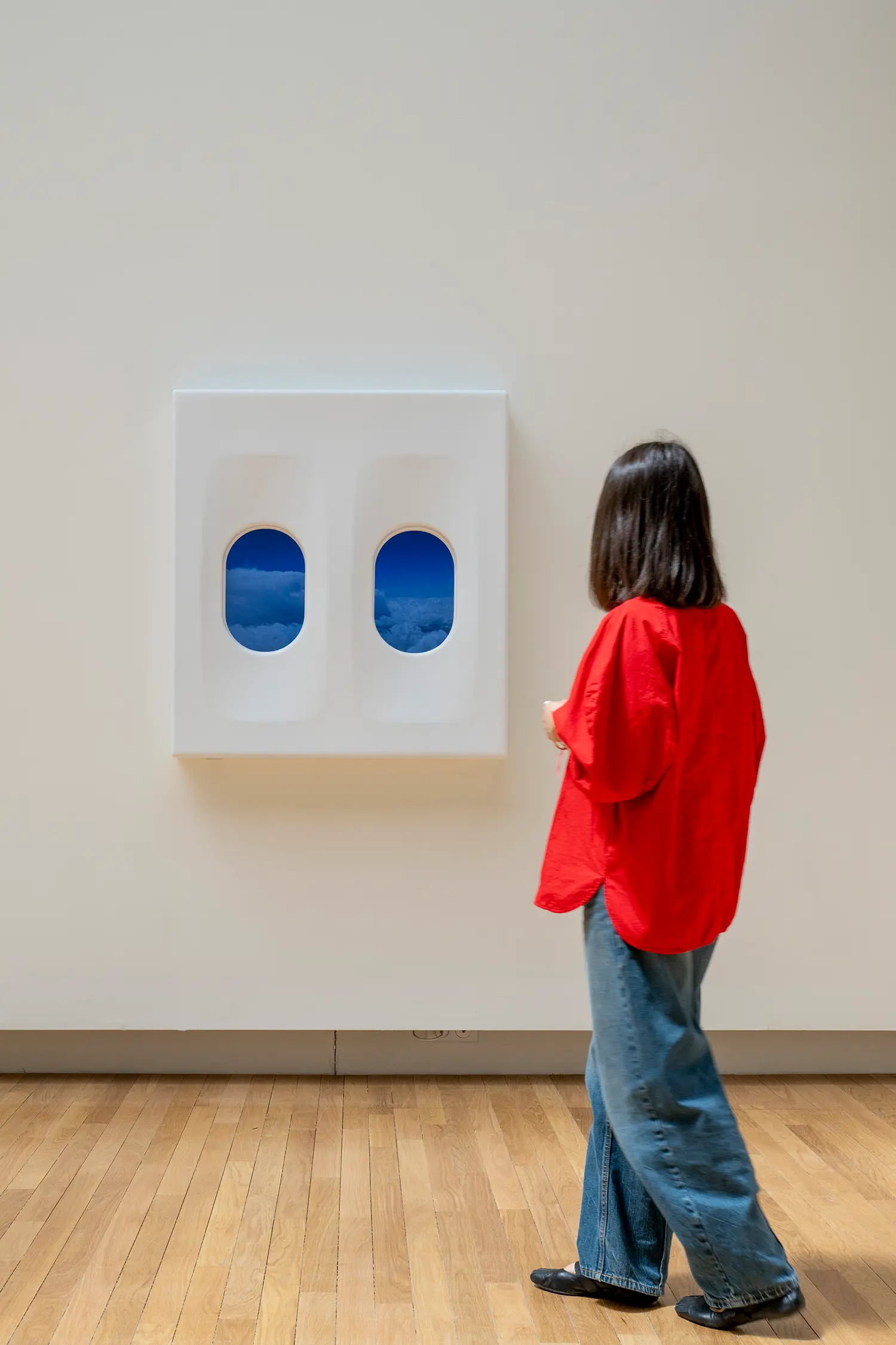Leandro Erlich airplane window installation Grand Palais Paris, white wall-mounted panel with two oval portholes showing blue sky and clouds below