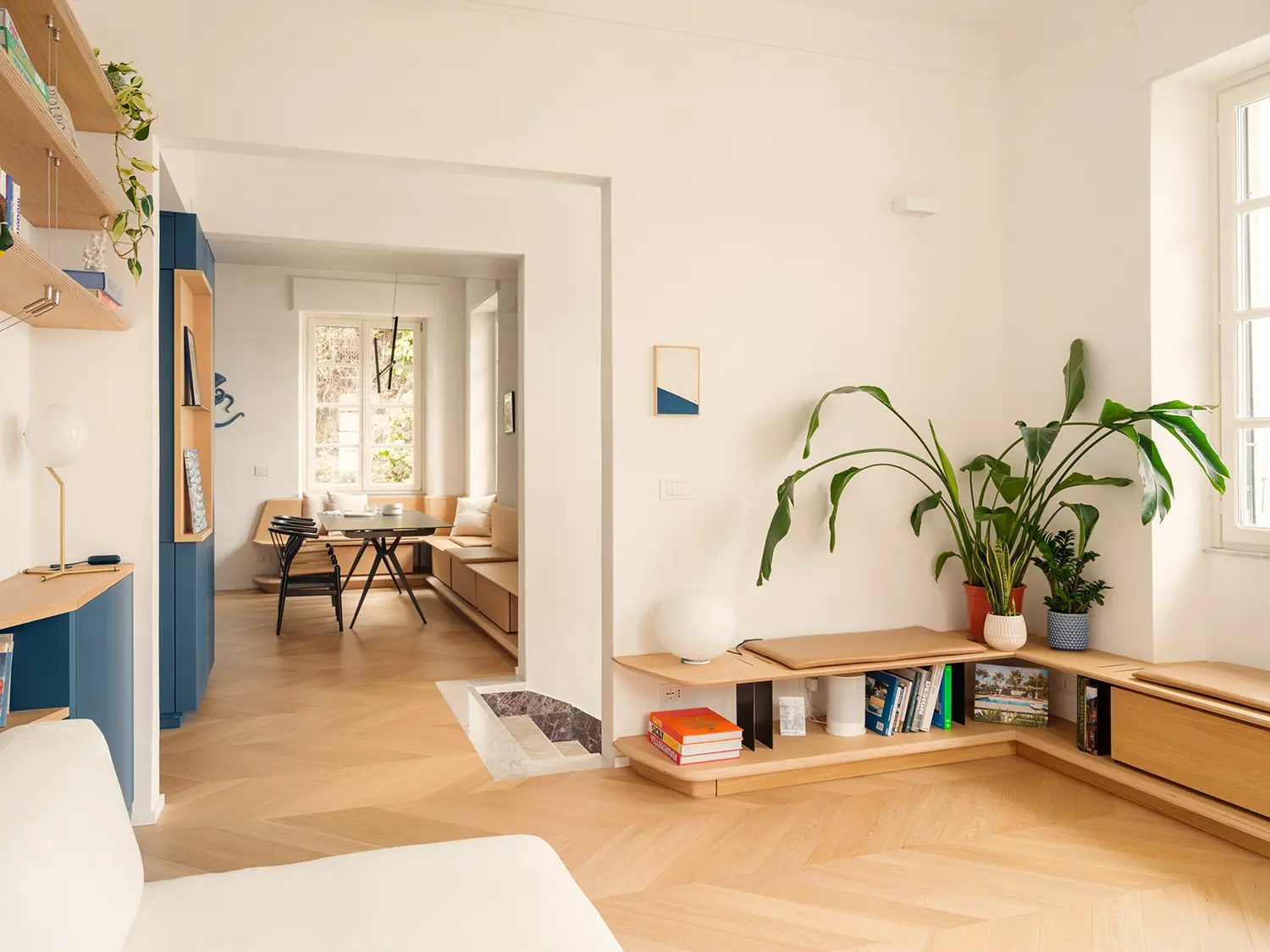 llabb Surf House Levanto living room oak millwork low bench bookcase blue lacquer kitchen enfilade herringbone parquet Levanto red marble threshold