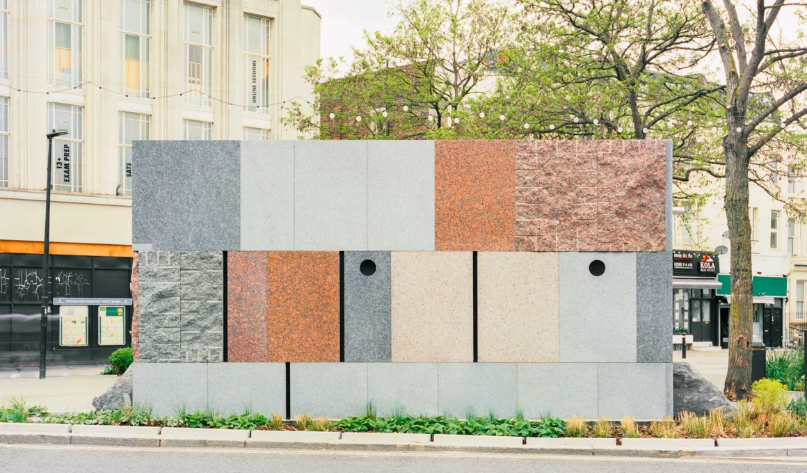 Maida Hill Public Toilets Studio Weave — reclaimed pink Finnish granite and Norwegian larvikite slabs, polished and split-face panels, load-bearing stone wall, street facade