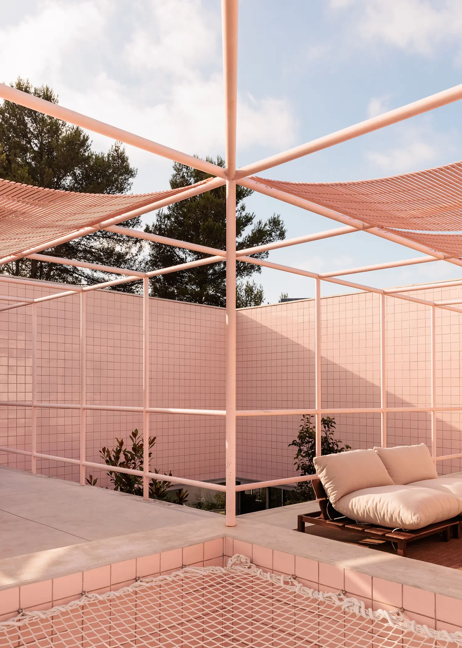 Casa Galamares atelier RUA pink tile courtyard terrace tubular steel pergola shade sails rope net daybed outdoor lounge