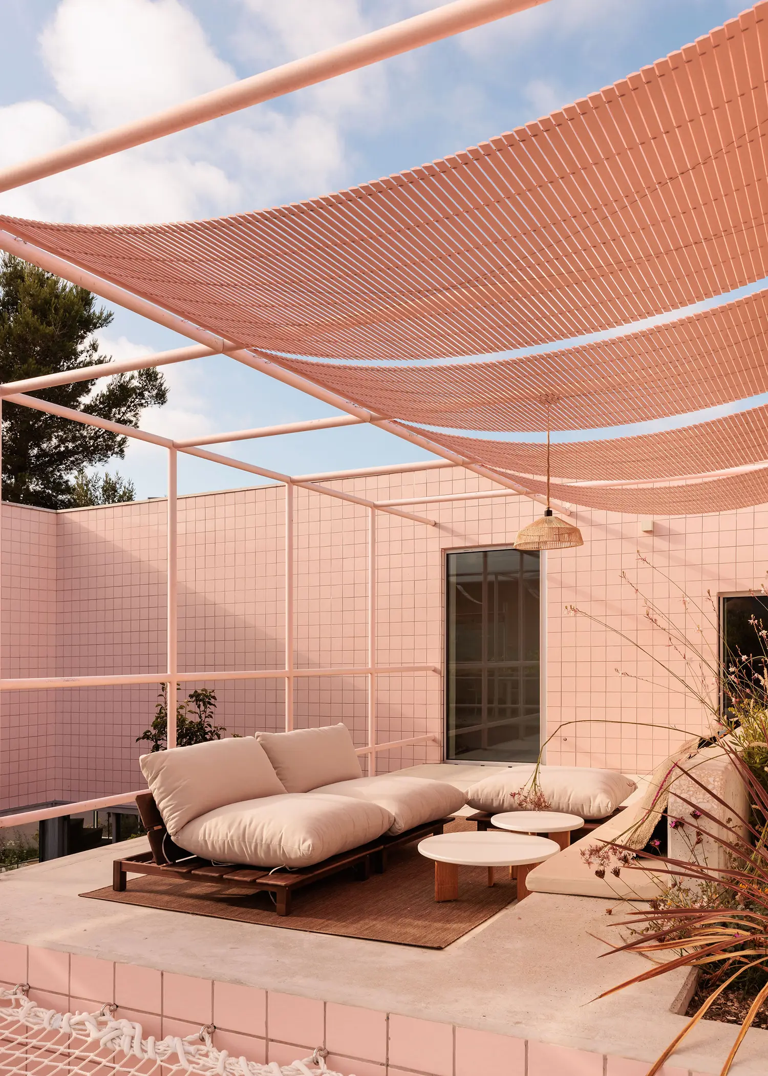 Casa Galamares atelier RUA rooftop terrace pink ceramic tile wall tubular steel frame shade sails rattan pendant outdoor furniture
