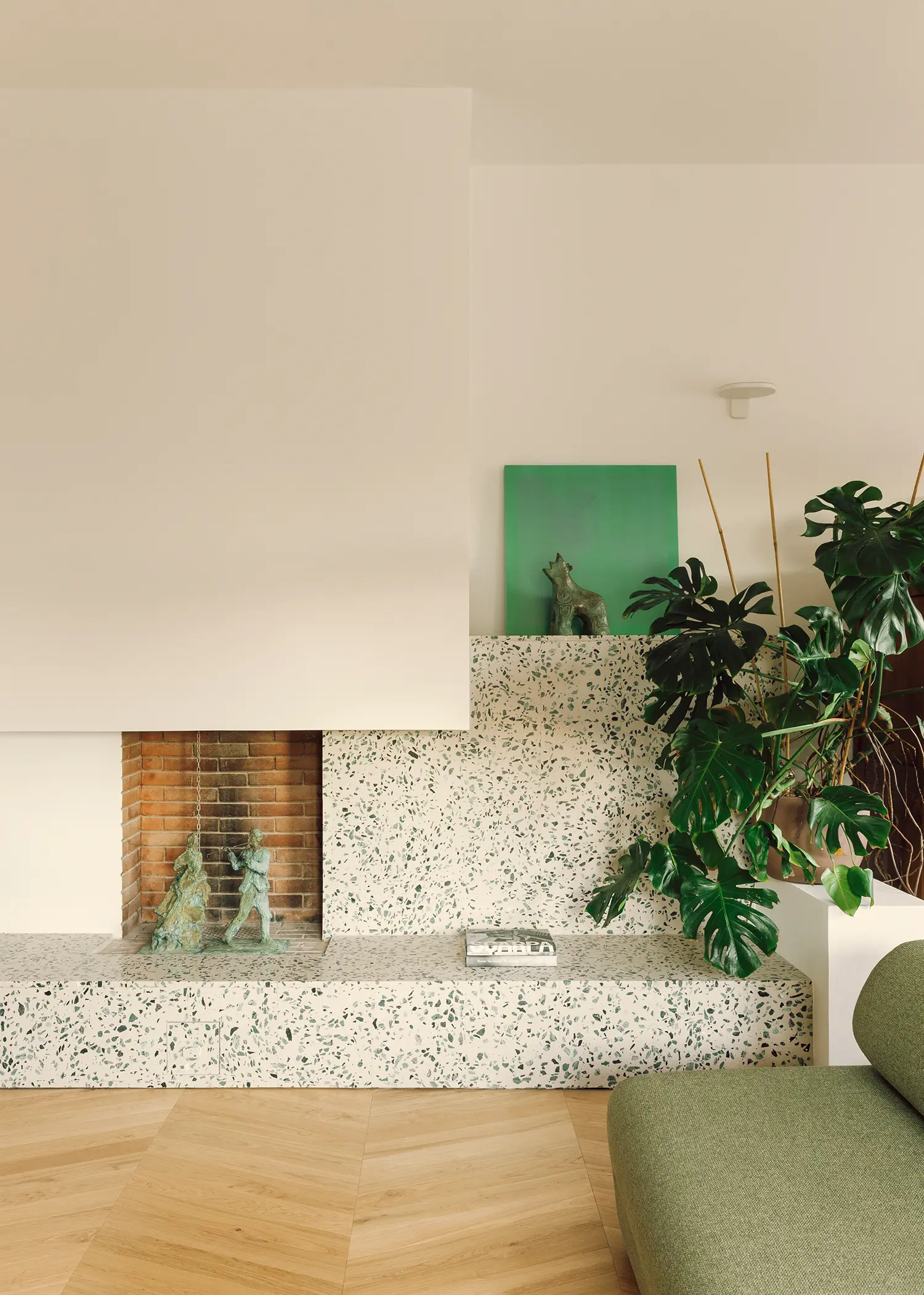 The Lobster bucci quentin, living room fireplace surround in speckled multicoloured terrazzo, oak herringbone parquet, Prato 2026