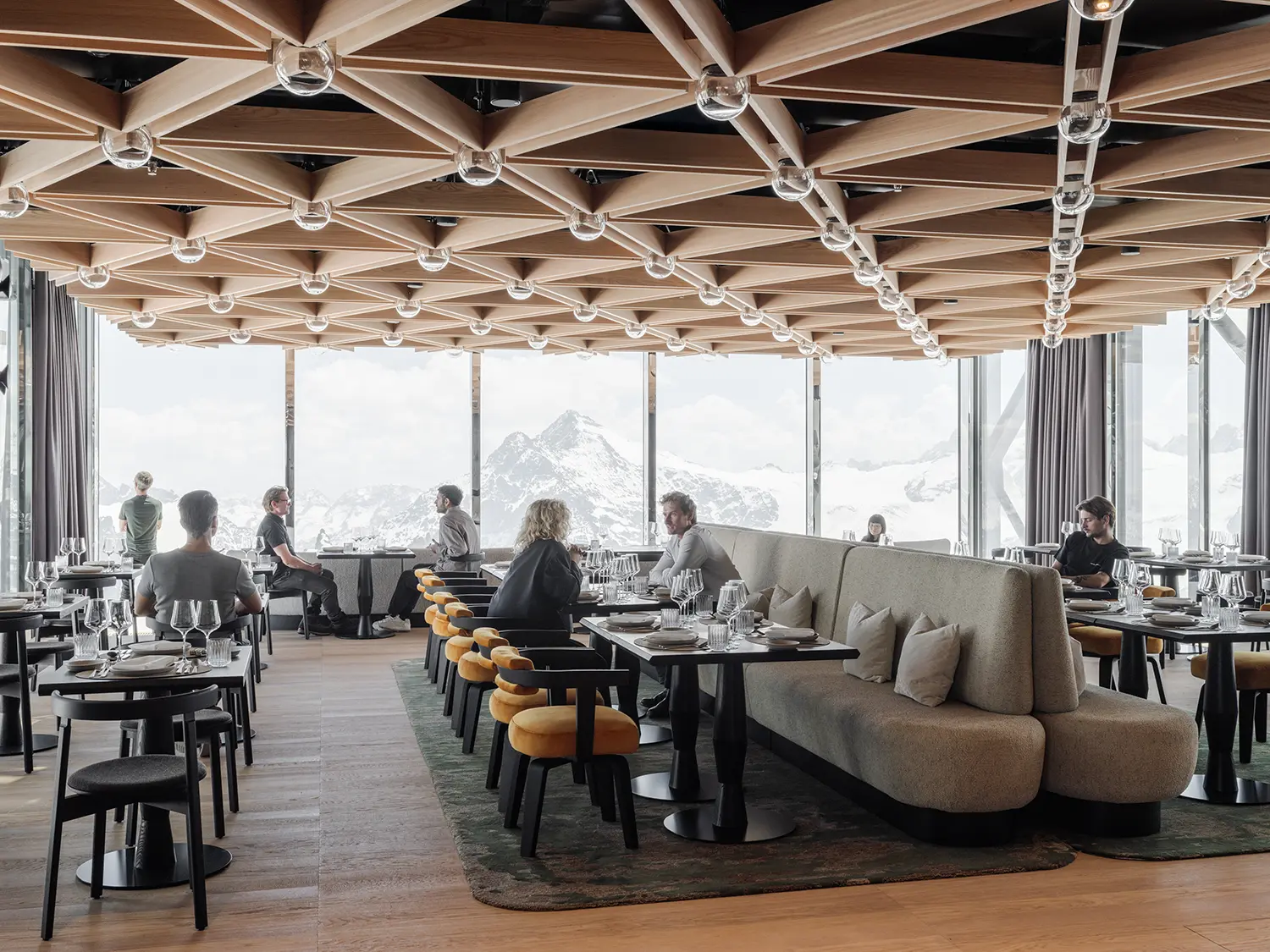 Joseph's Restaurant TITLIS Tower Herzog de Meuron wood lattice ceiling globe lights floor-to-ceiling glazing alpine panorama diners