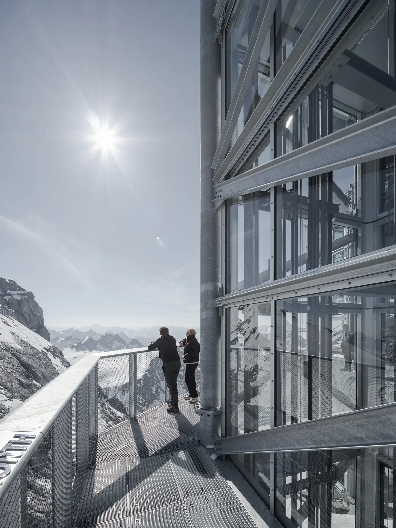 TITLIS Tower Herzog de Meuron Horizon Deck viewing platform two visitors galvanized steel mesh alpine panorama sunlight