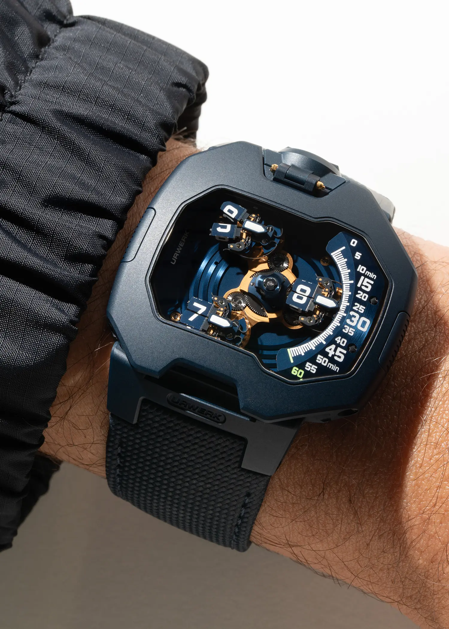 URWERK UR-120 Blue Planet full case on wrist against white background, sandblasted steel, satellite display, gold PVD carousel, blue Cordura strap
