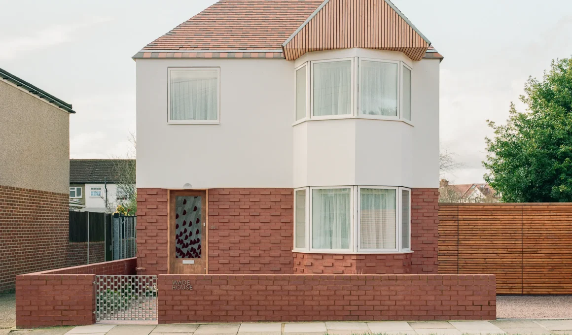 Front elevation of Wade House by Wadhal in Ruislip, two-storey new-build with red brick base, white render upper level, fired-clay tiled roof, and timber-clad gable end