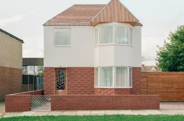 Front elevation of Wade House by Wadhal in Ruislip, two-storey new-build with red brick base, white render upper level, fired-clay tiled roof, and timber-clad gable end