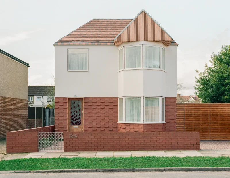 Front elevation of Wade House by Wadhal in Ruislip, two-storey new-build with red brick base, white render upper level, fired-clay tiled roof, and timber-clad gable end